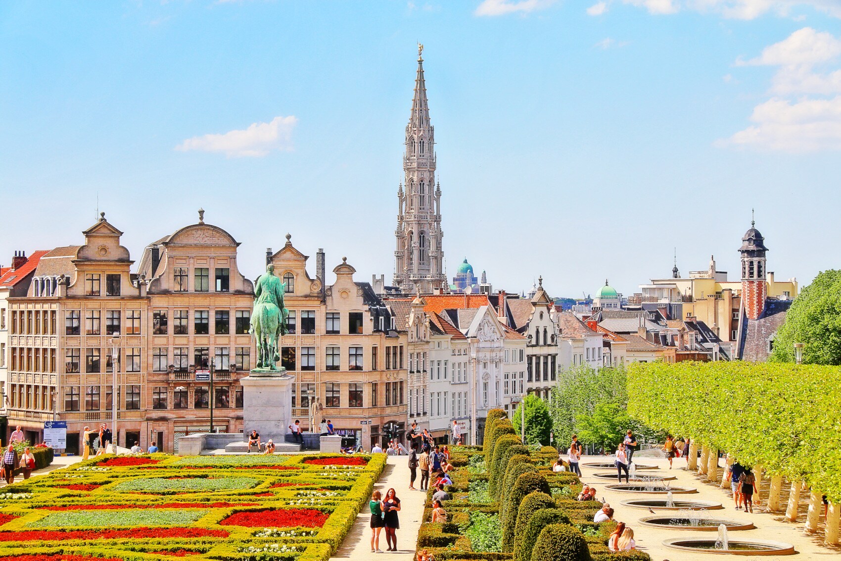 Blick auf symmetrisch angelegten Garten, dahinter historische Häuserfassaden und eine Kirche Blick auf symmetrisch angelegten Garten, dahinter historische Häuserfassaden und eine Kirche