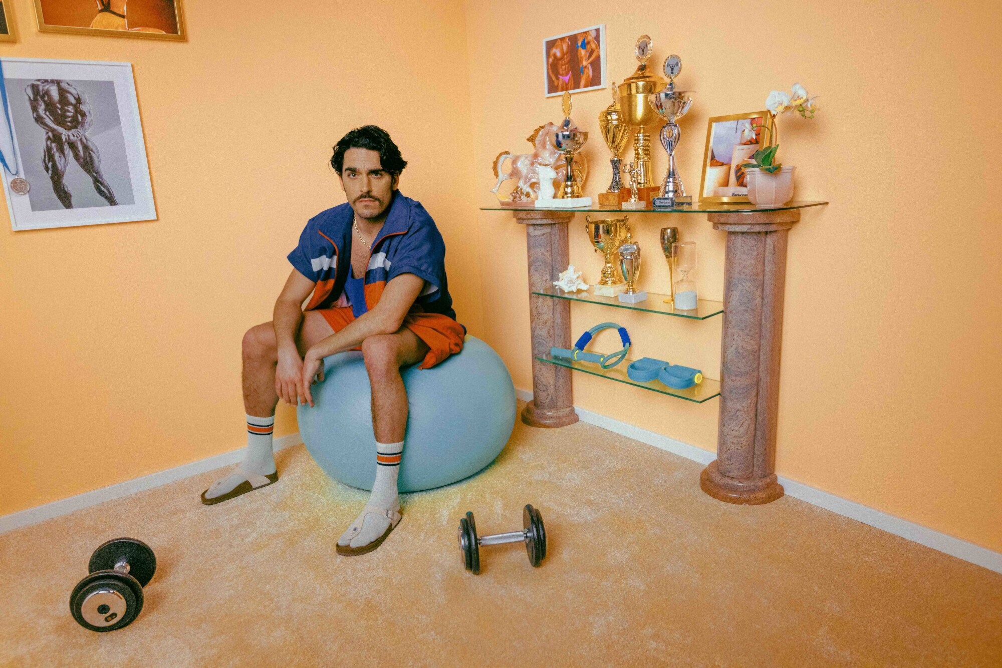 Ein Mann mit Schnauzbart in Shorts trägt das Birkenstock-Modell Gizeh mit weißen Socken, Werbekampagne Ein Mann mit Schnauzbart in Shorts trägt das Birkenstock-Modell Gizeh mit weißen Socken, Werbekampagne