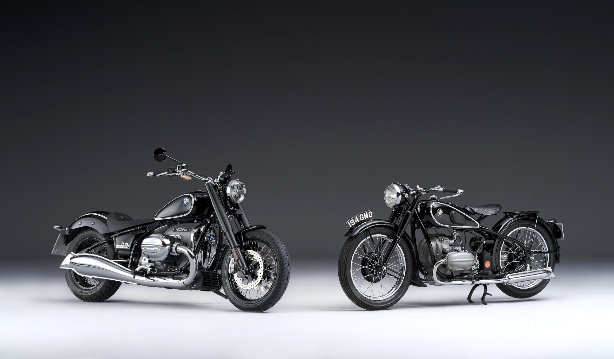 Studioaufnahme von zwei schwarzen BMW-Motorrädern R 18 und R 5 mit Chromdetails im Cruiser-Stil vor schwarzem Hintergrund Studioaufnahme von zwei schwarzen BMW-Motorrädern R 18 und R 5 mit Chromdetails im Cruiser-Stil vor schwarzem Hintergrund