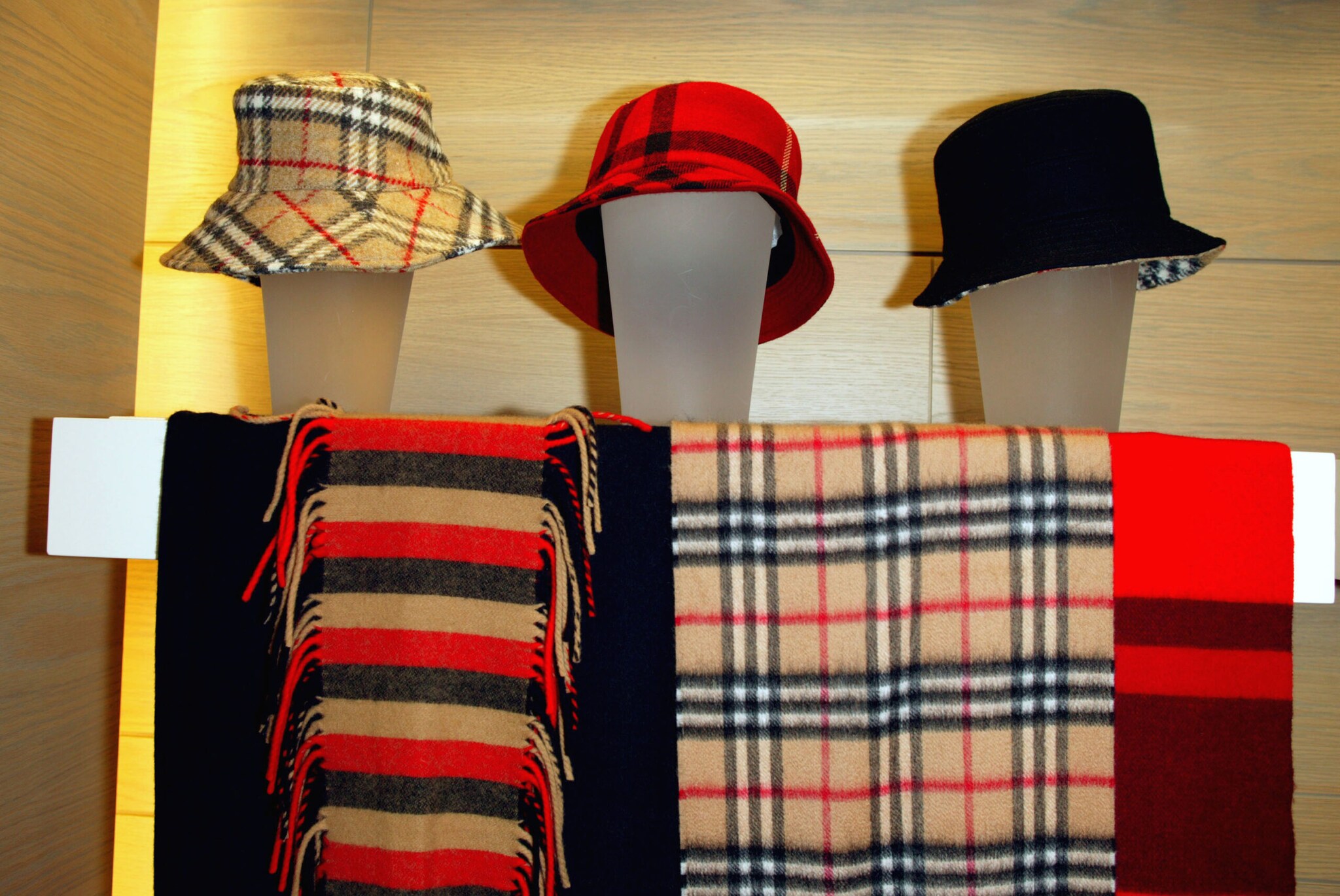 Hüte und Schals mit Karos und Streifen in einem Schaufenster. Hüte und Schals mit Karos und Streifen in einem Schaufenster.