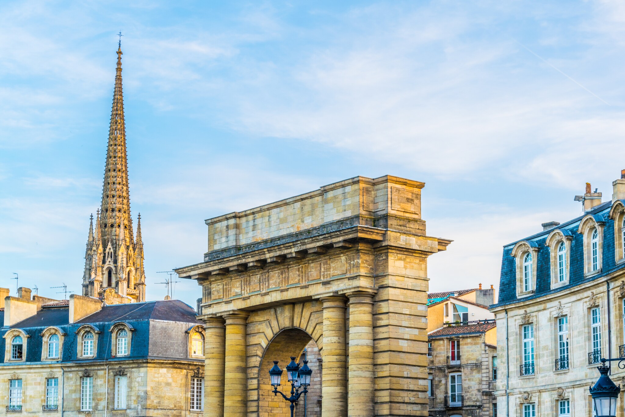 Stadtpanorama der historischen Altstadt von Bordeaux mit Torbogen und Kirchturmspitze