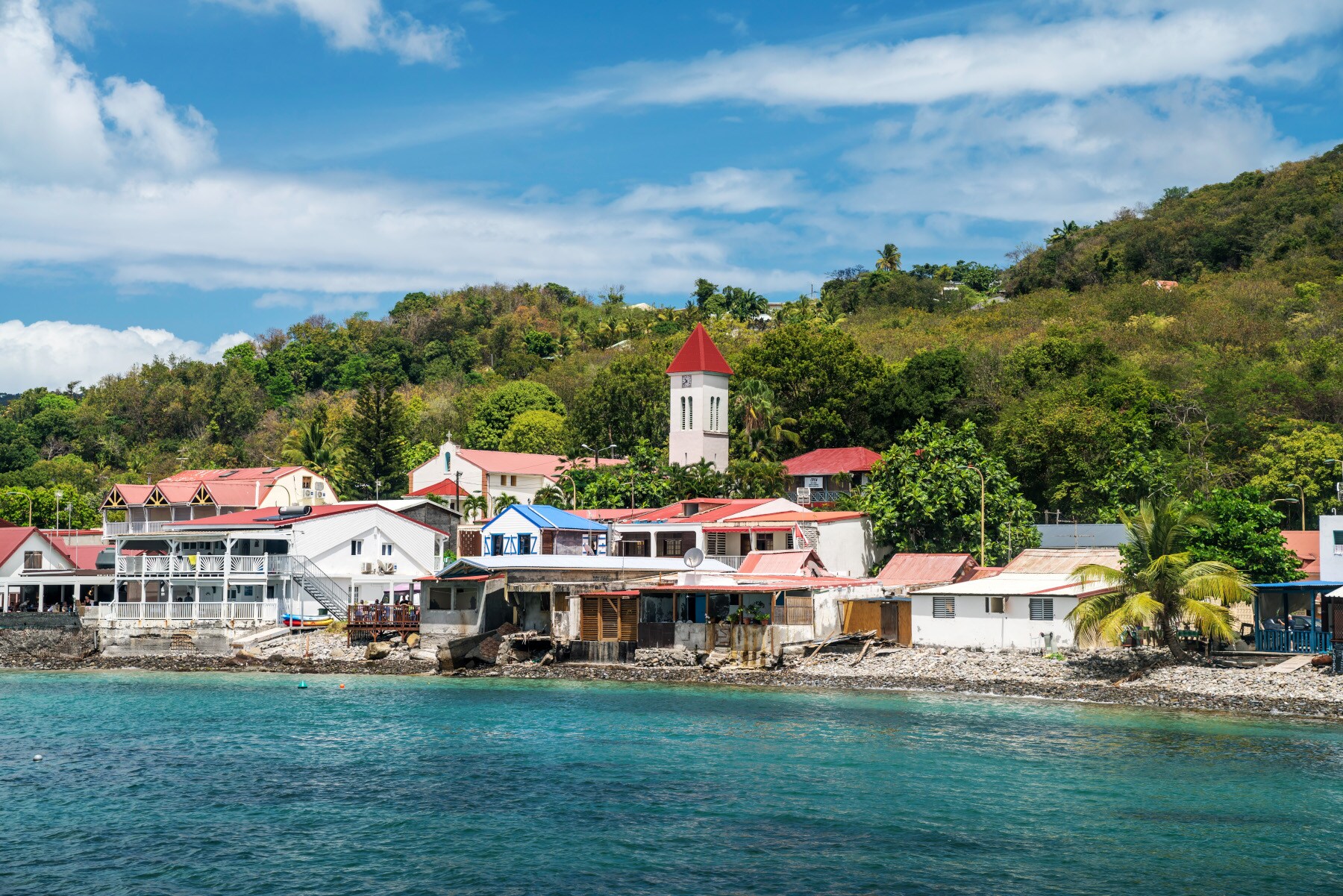 Ein kleines, karibisches Fischerdorf am Meer, umgeben von tropischer Vegetation Ein kleines, karibisches Fischerdorf am Meer, umgeben von tropischer Vegetation