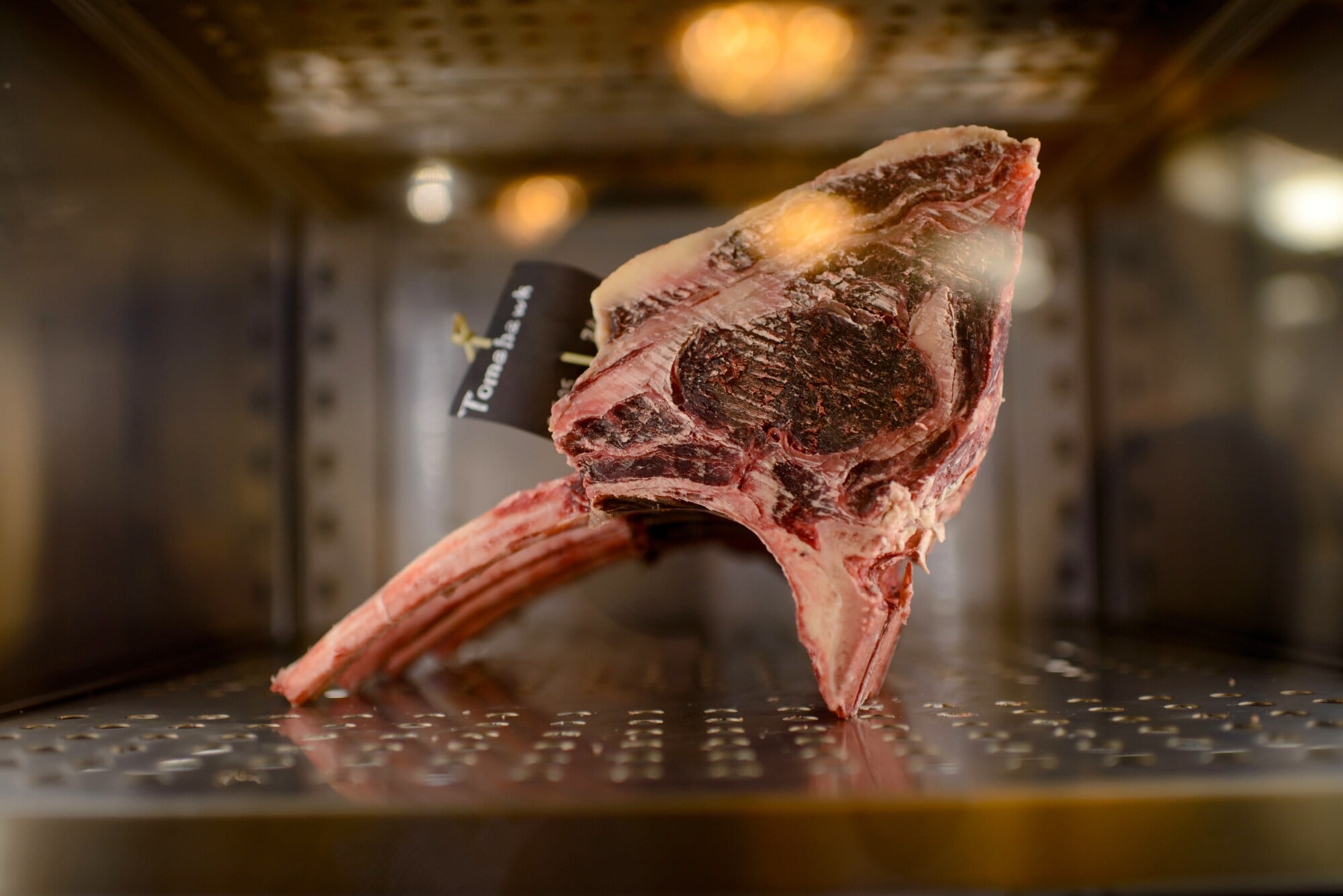 Ein Stück Tomahawk Steak während der Trockenreifung Ein Stück Tomahawk Steak während der Trockenreifung