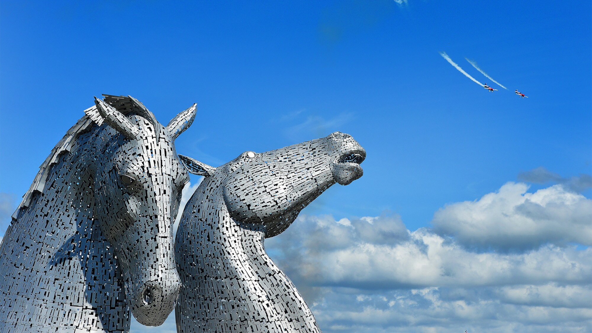 Aufnahme von zwei Pferdeköpfen aus Metall vor blauem Himmel