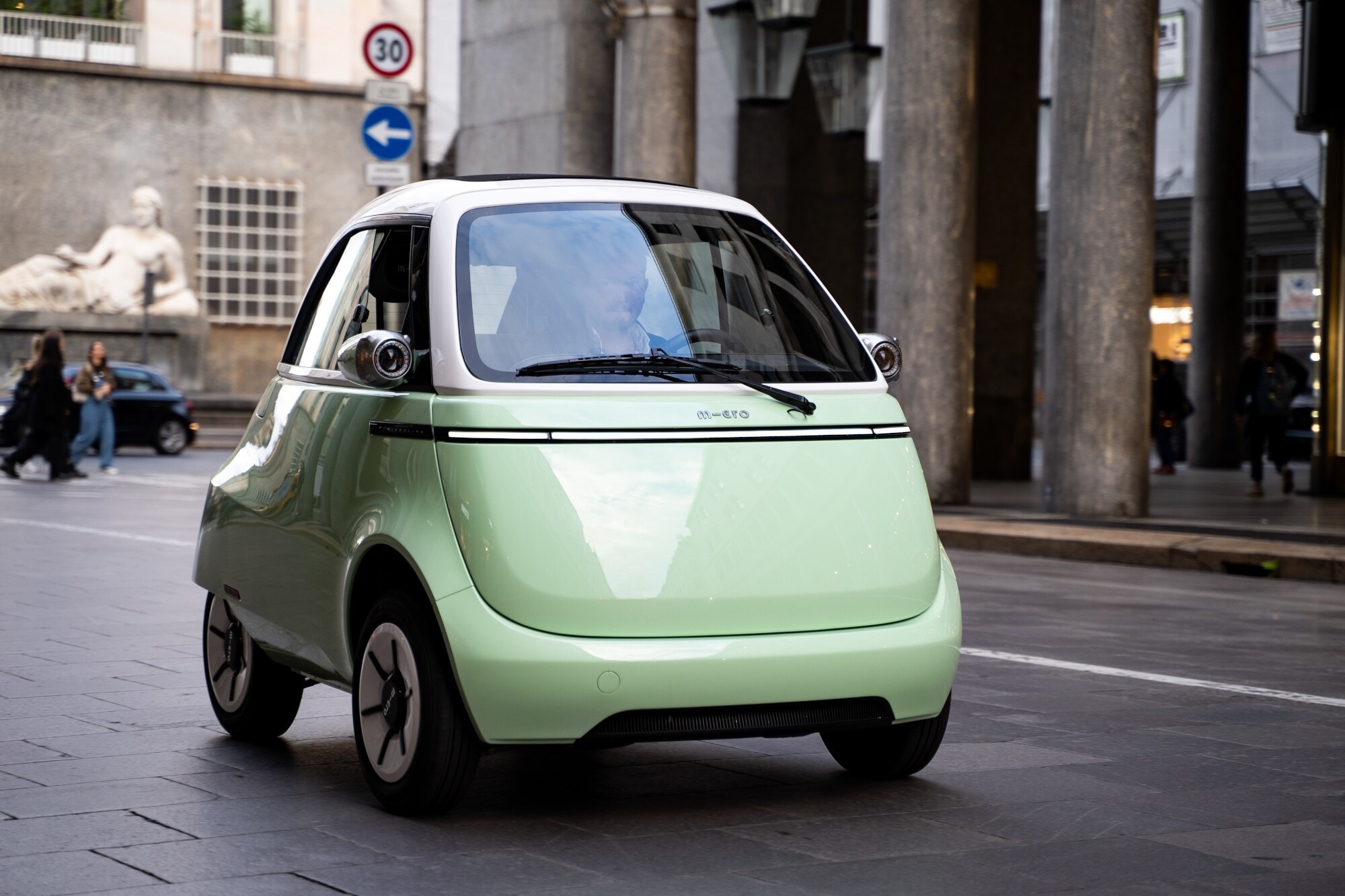 Mintfarbenes Elektrokleinfahrzeug auf einer Straße Mintfarbenes Elektrokleinfahrzeug auf einer Straße