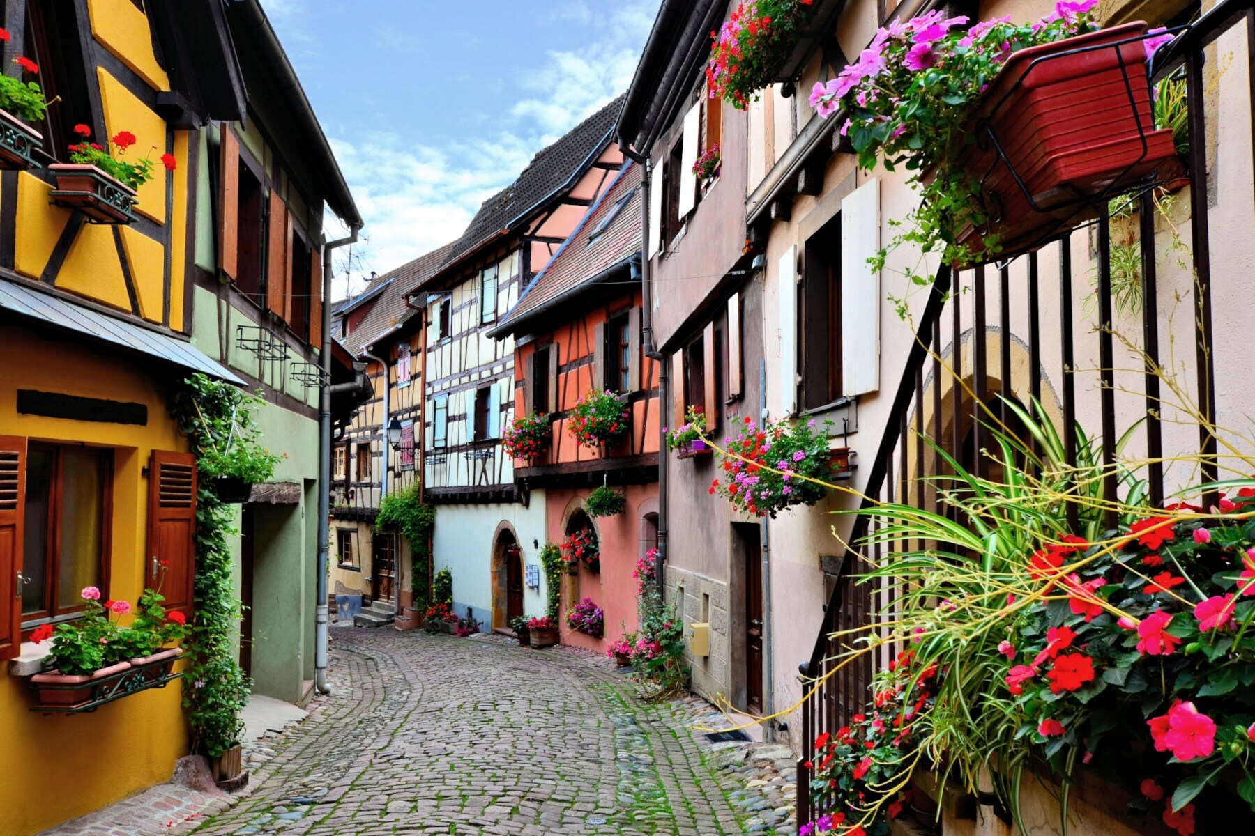 Pittoreske, kopfsteingepflasterte Gasse mit bunten Fachwerkhäusern mit Blumenkästen Pittoreske, kopfsteingepflasterte Gasse mit bunten Fachwerkhäusern mit Blumenkästen