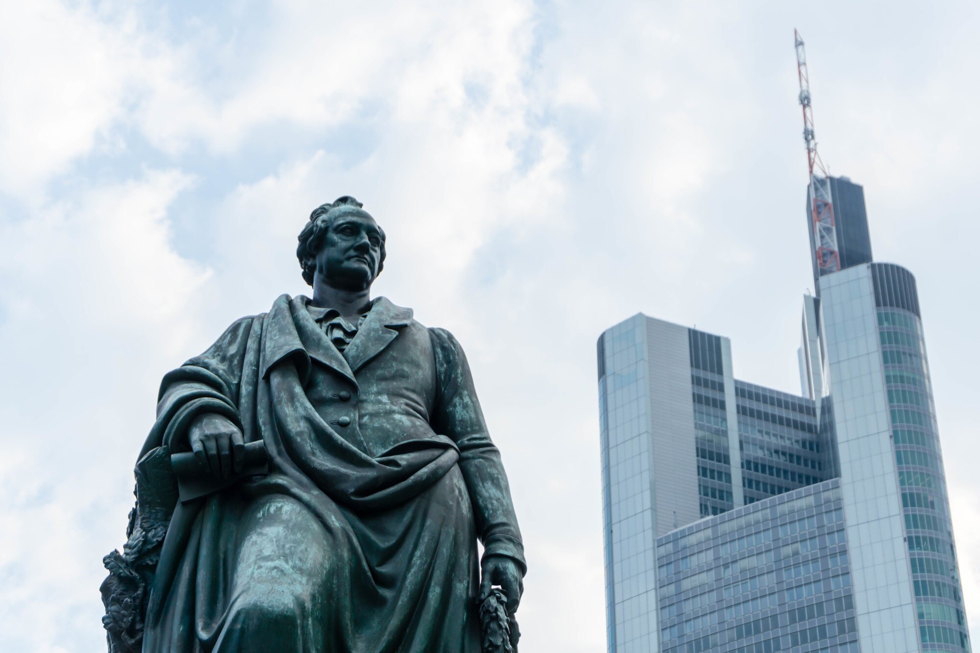 Statue von Johann Wolfgang von Goethe mit modernem Hochhaus im Hintergrund Statue von Johann Wolfgang von Goethe mit modernem Hochhaus im Hintergrund