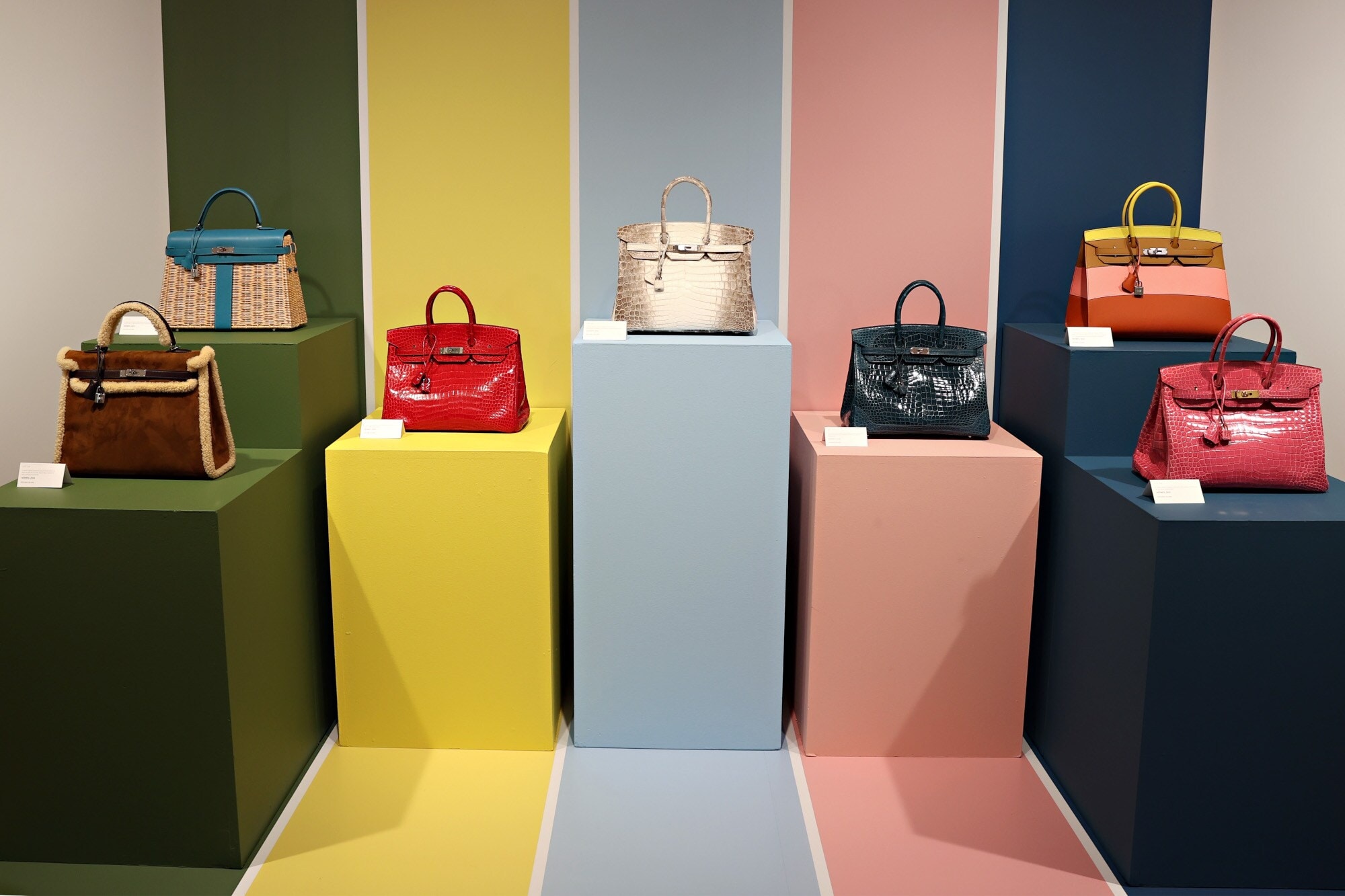 Handtaschen ausgestellt auf bunten Podesten Handtaschen ausgestellt auf bunten Podesten