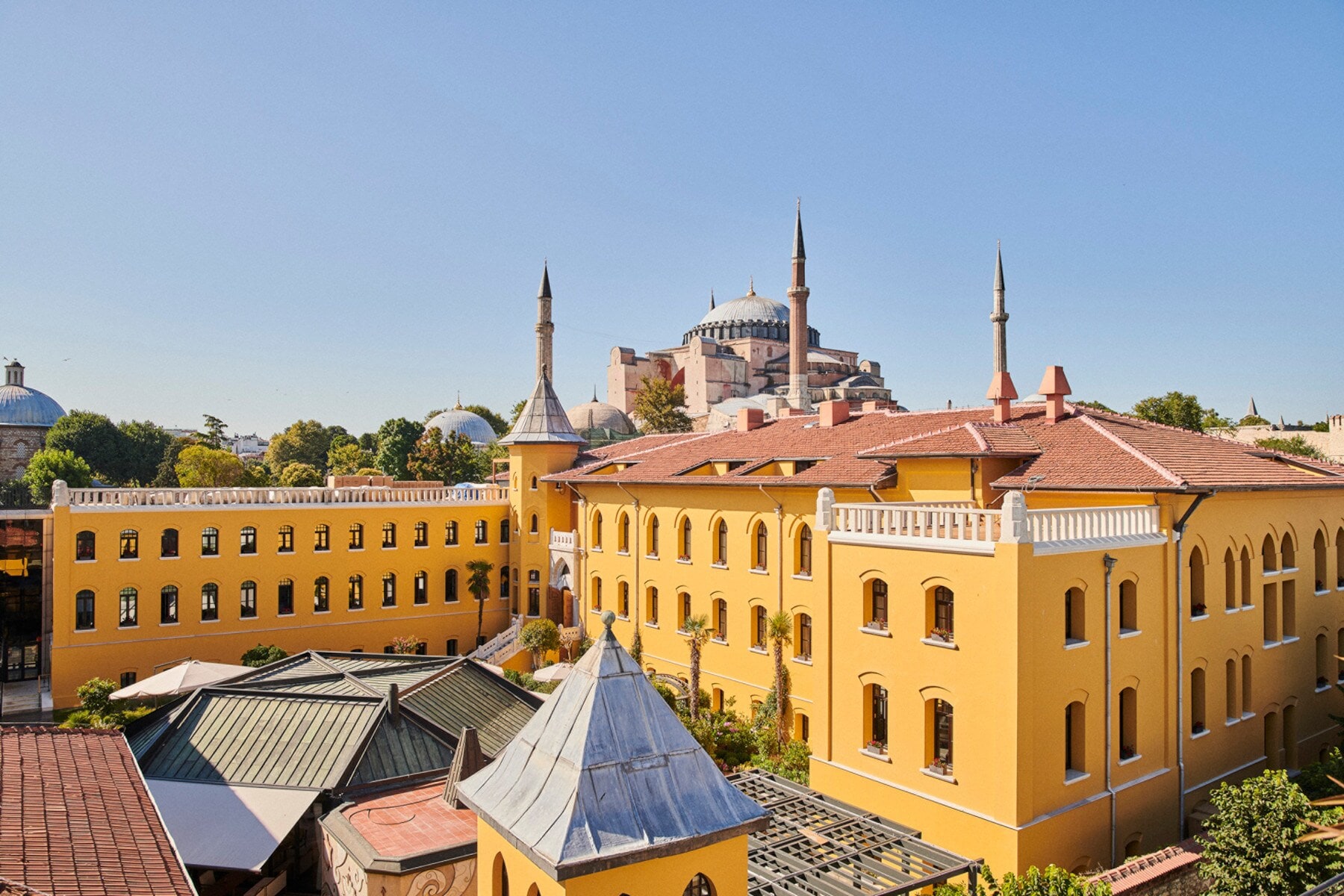 Ein gelbes, neoklassizistisches Gebäude mit Innenhof und einer Moschee im Hintergrund Ein gelbes, neoklassizistisches Gebäude mit Innenhof und einer Moschee im Hintergrund