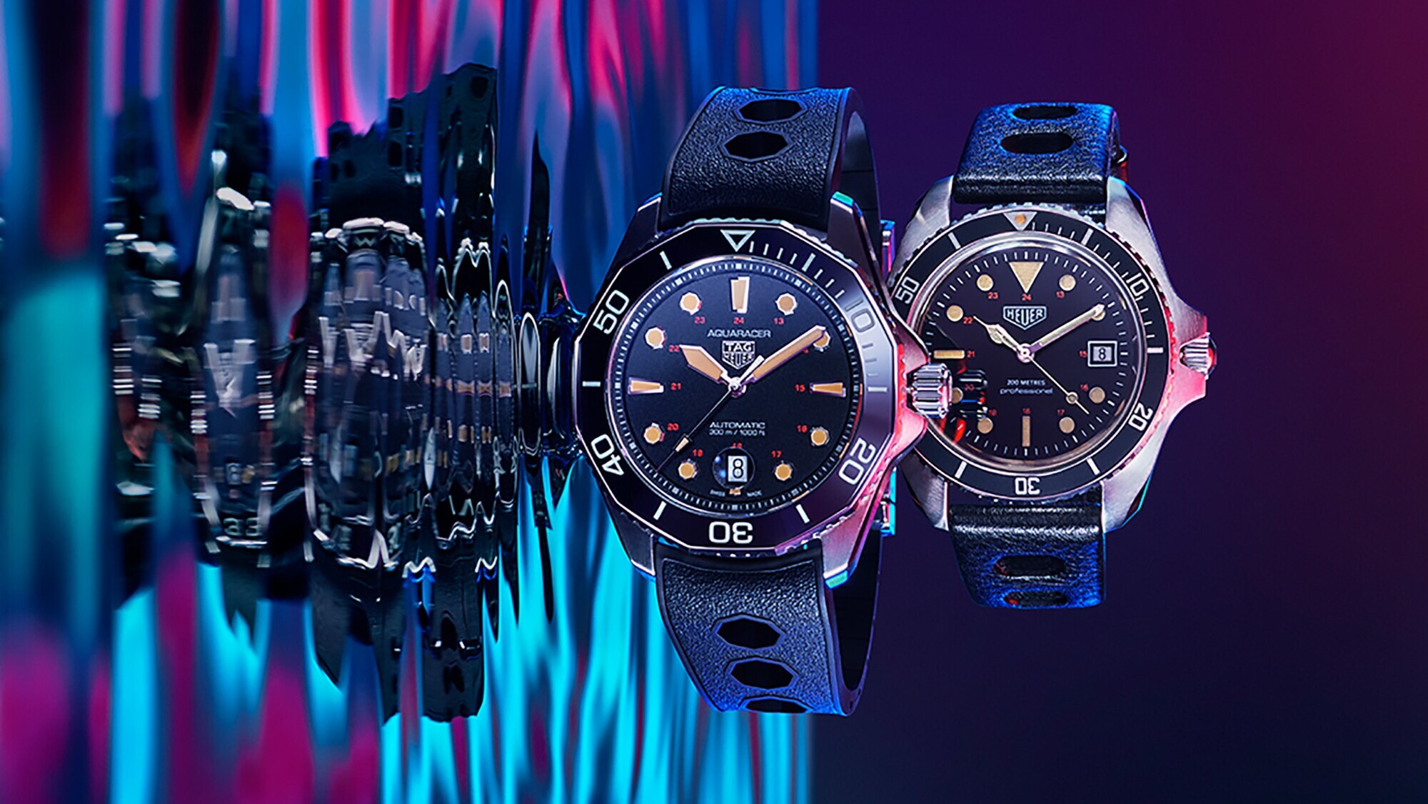 Produktaufnahme, Close-up zweier Taucheruhren von TAG Heuer mit schwarzem Zifferblatt und Kunststoffarmband auf farbigem Untergrund mit Wassermotiv