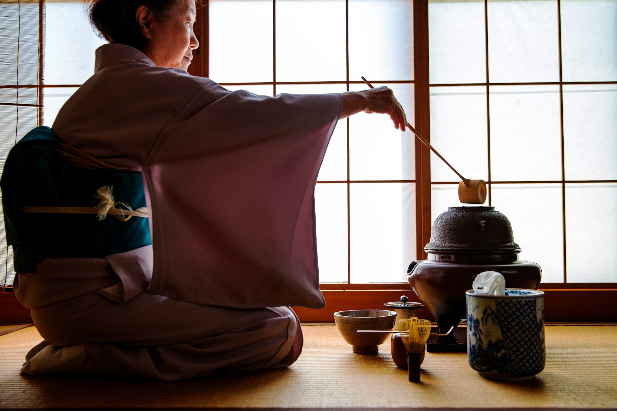 Eine Frau im Kimono bei einer traditionell japanischen Teezeremonie Eine Frau im Kimono bei einer traditionell japanischen Teezeremonie