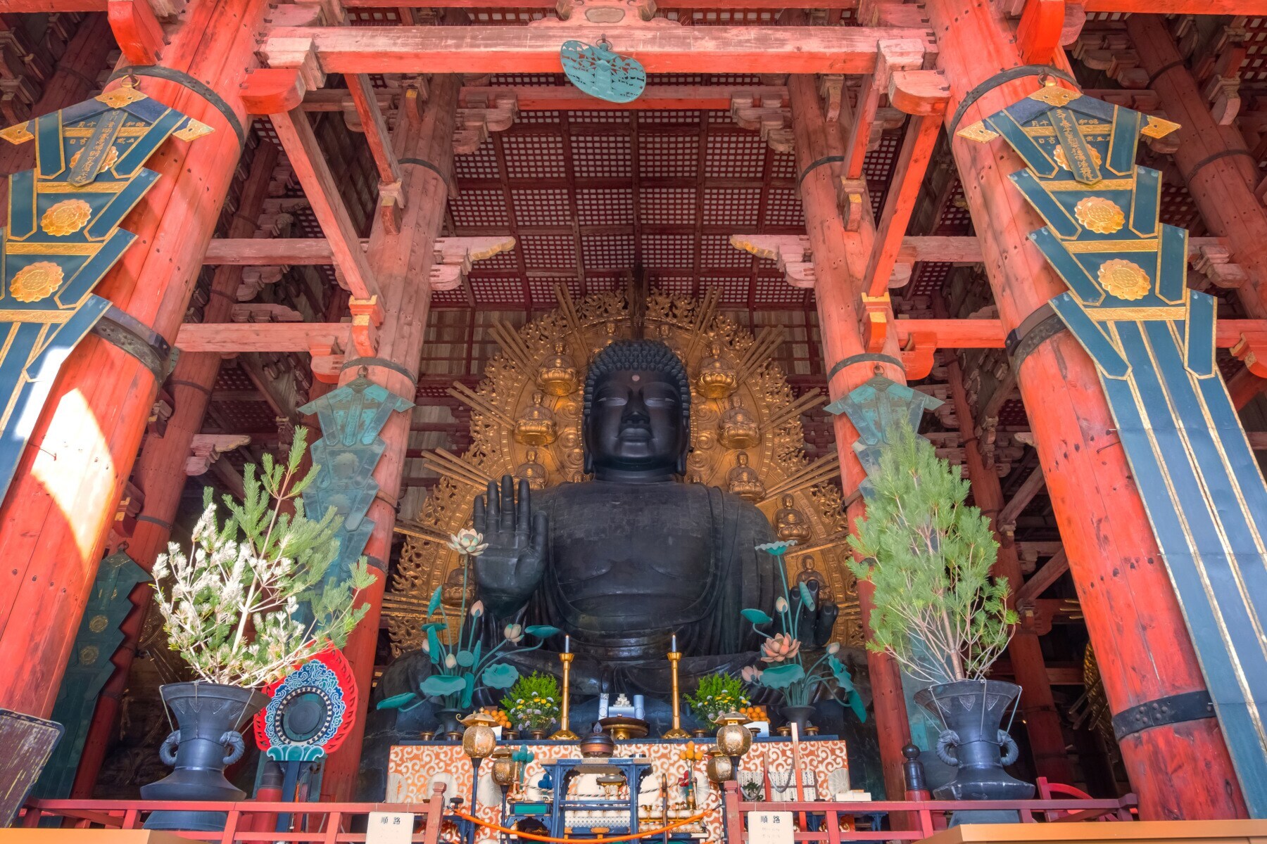 Überdimensionale bronzene Buddhastatue, davor ein Altar Überdimensionale bronzene Buddhastatue, davor ein Altar