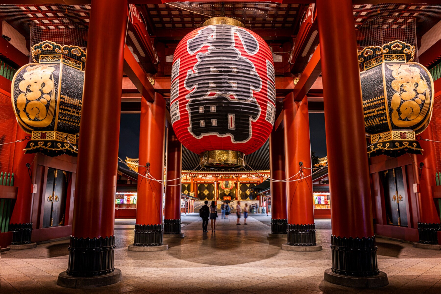 Rote Säulen und überdimensionale Laternen mit japanischen Schriftzügen in einem Tempel Rote Säulen und überdimensionale Laternen mit japanischen Schriftzügen in einem Tempel