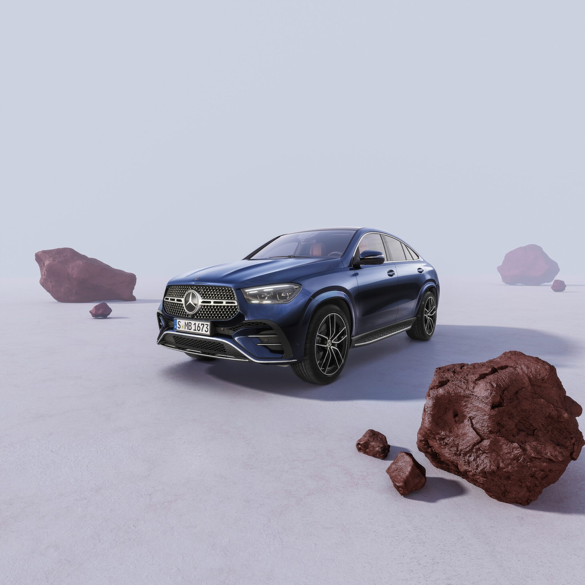 Blaues Mercedes-Benz GLE Coupé seitlich von vorne in einer hellen Umgebung mit braunen Felsbrocken Blaues Mercedes-Benz GLE Coupé seitlich von vorne in einer hellen Umgebung mit braunen Felsbrocken