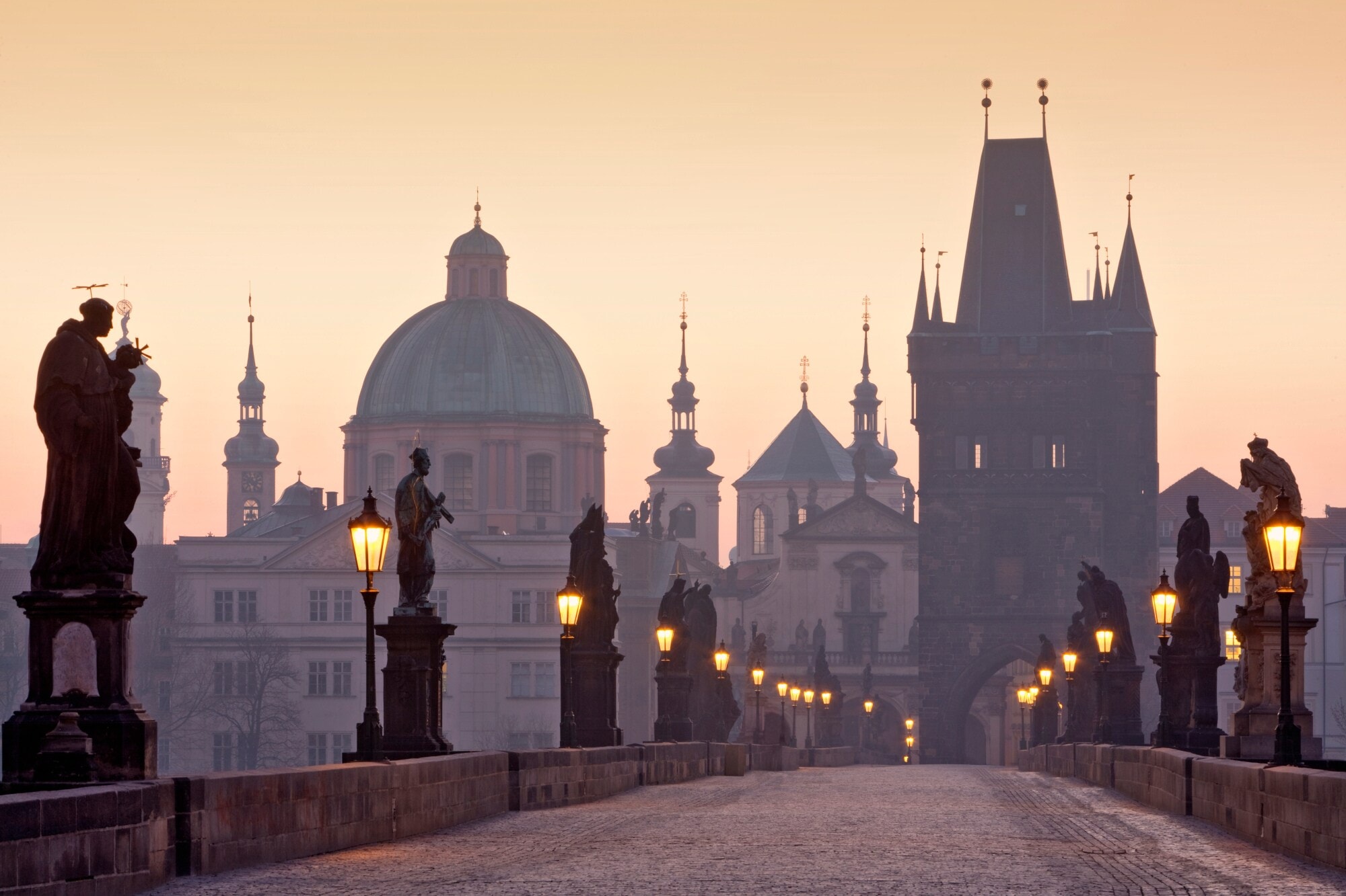 Karlsbrücke mit steinernen Statuen vor Stadtpanorama von Prag Karlsbrücke mit steinernen Statuen vor Stadtpanorama von Prag