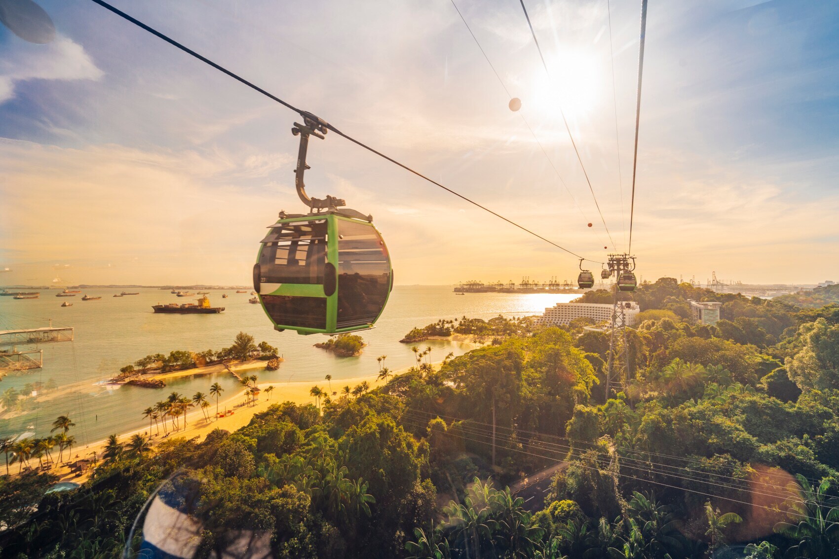 Eine Seilbahn über der tropischen Insel Sentosa Island mit Sandstränden bei Sonnenuntergang