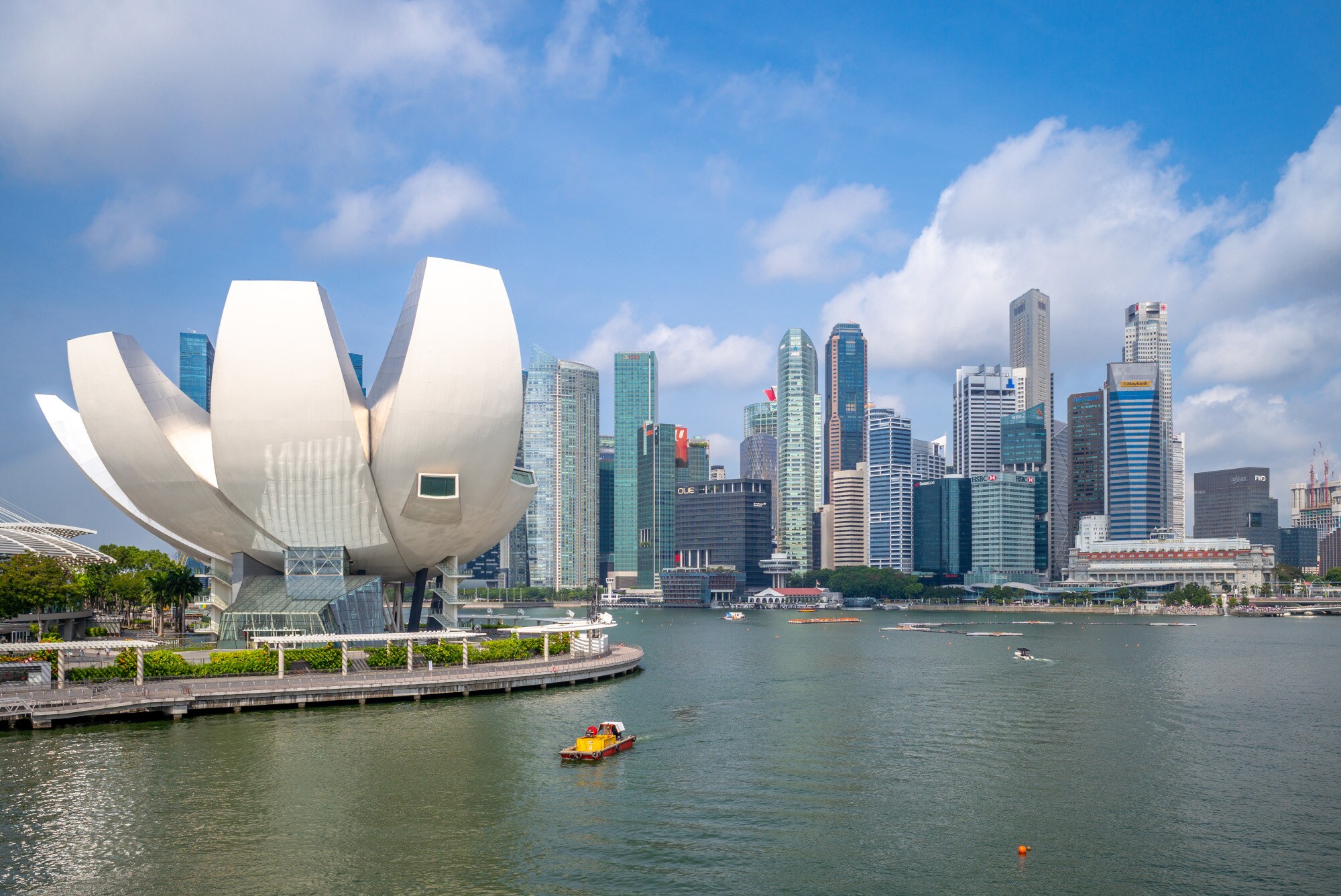 Skyline von Singapur an der Marina Bay mit einem weißen, modernen Museumsgebäude in Lotusblütenform im Vordergrund