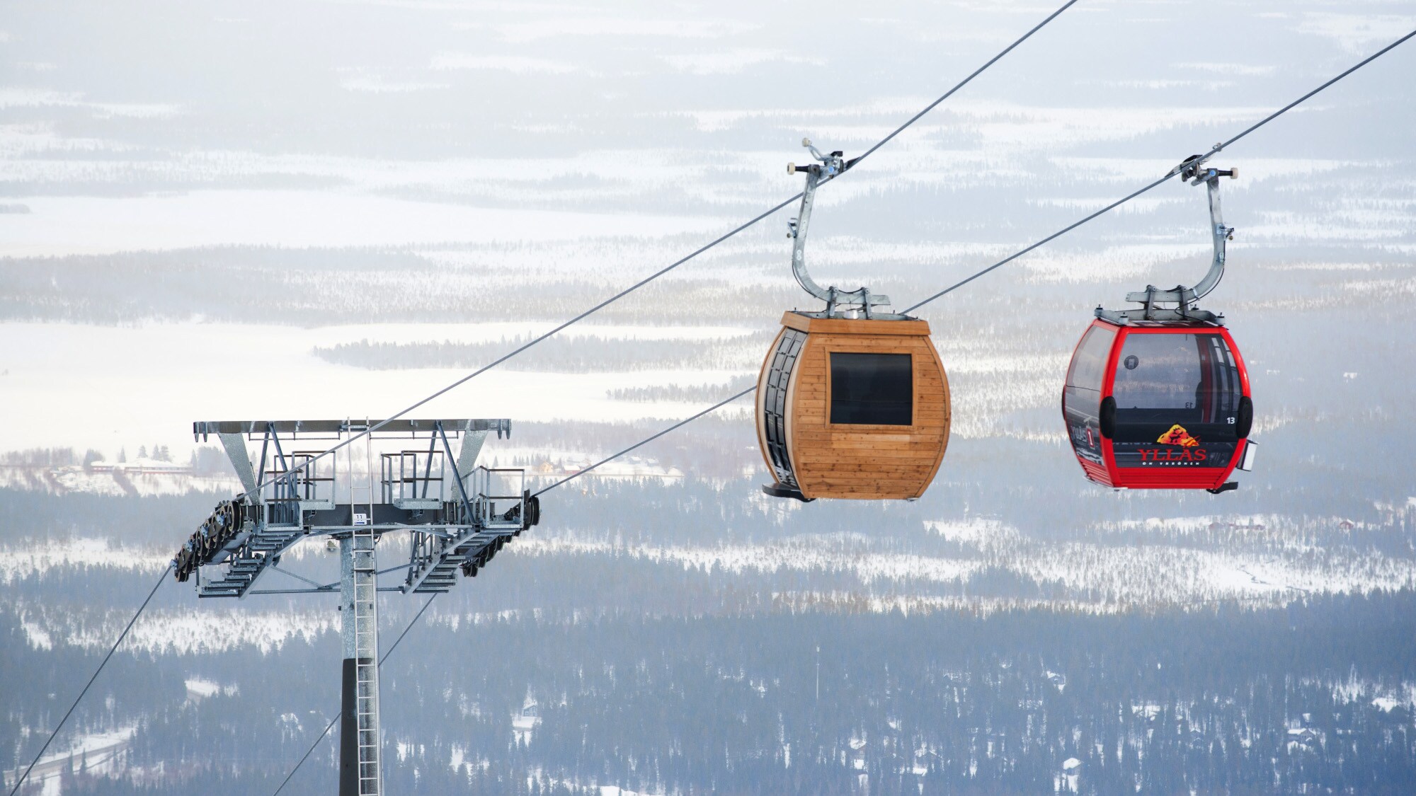 Seilbahn mit hölzerner Gondel mit Sauna vor Schneelandschaft Seilbahn mit hölzerner Gondel mit Sauna vor Schneelandschaft