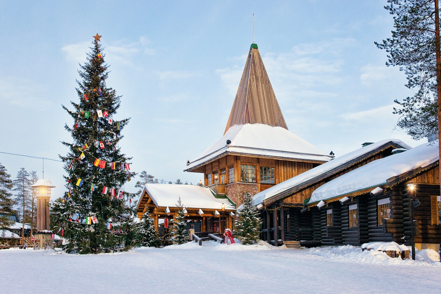 Holzhäuser in einem schneebedeckten Dorf mit geschmücktem Weihnachtsbaum