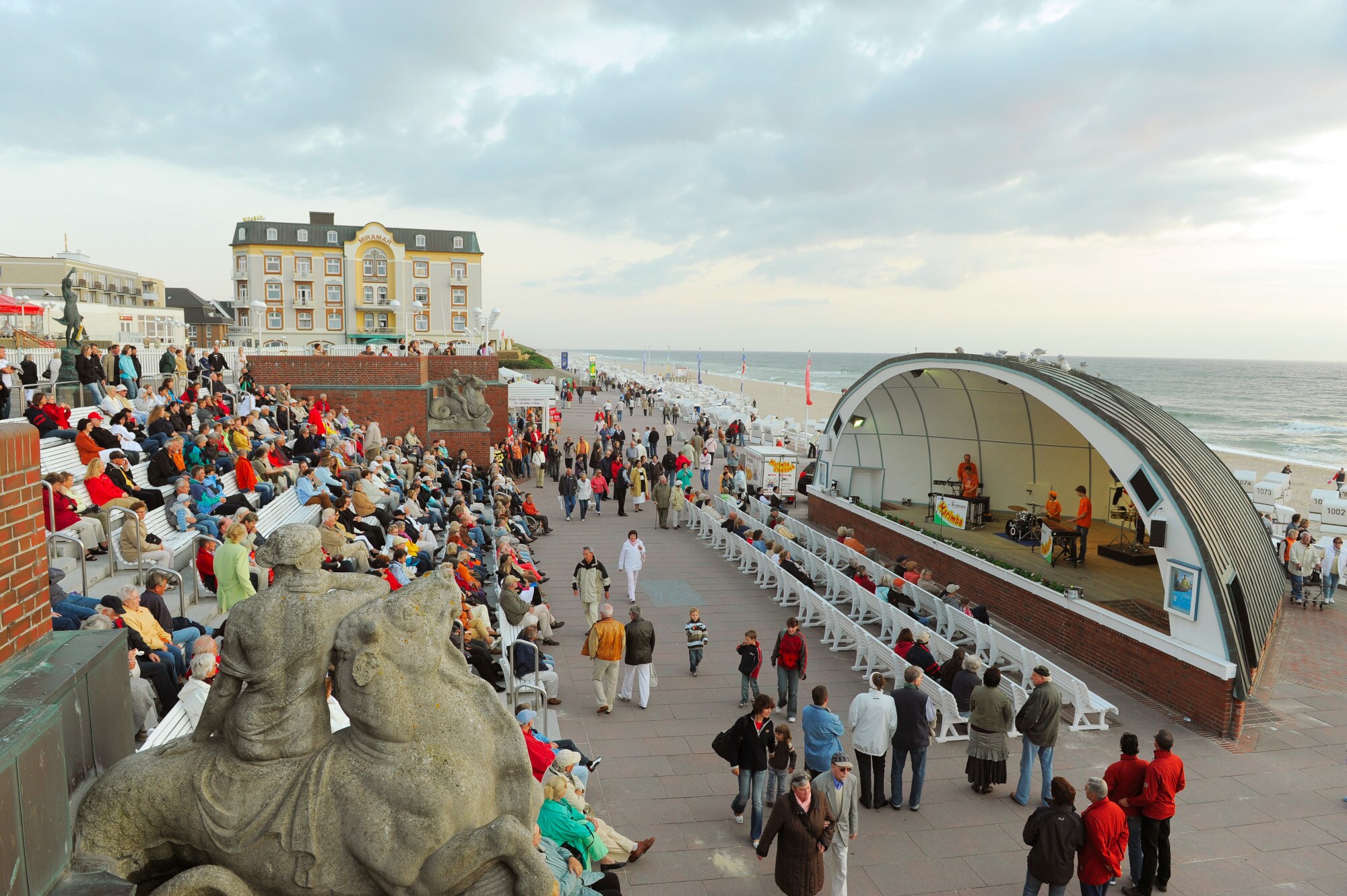 Belebte Strandpromenade von Westerland mit Zuschauern eines Konzertes in einer Musikmuschel Belebte Strandpromenade von Westerland mit Zuschauern eines Konzertes in einer Musikmuschel