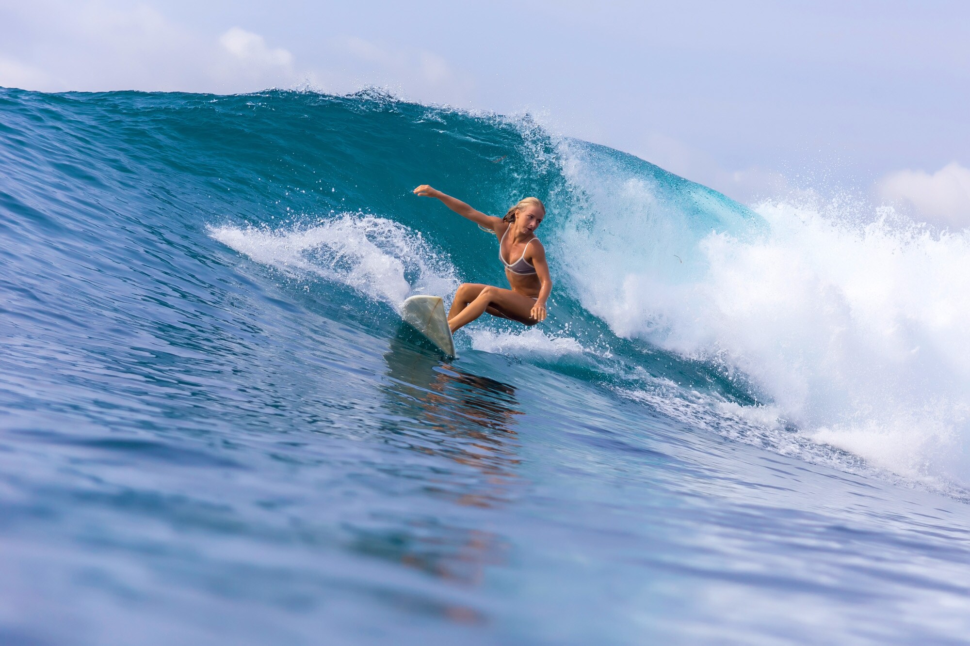 Eine junge Surferin im Bikini reitet auf einer großen Welle Eine junge Surferin im Bikini reitet auf einer großen Welle