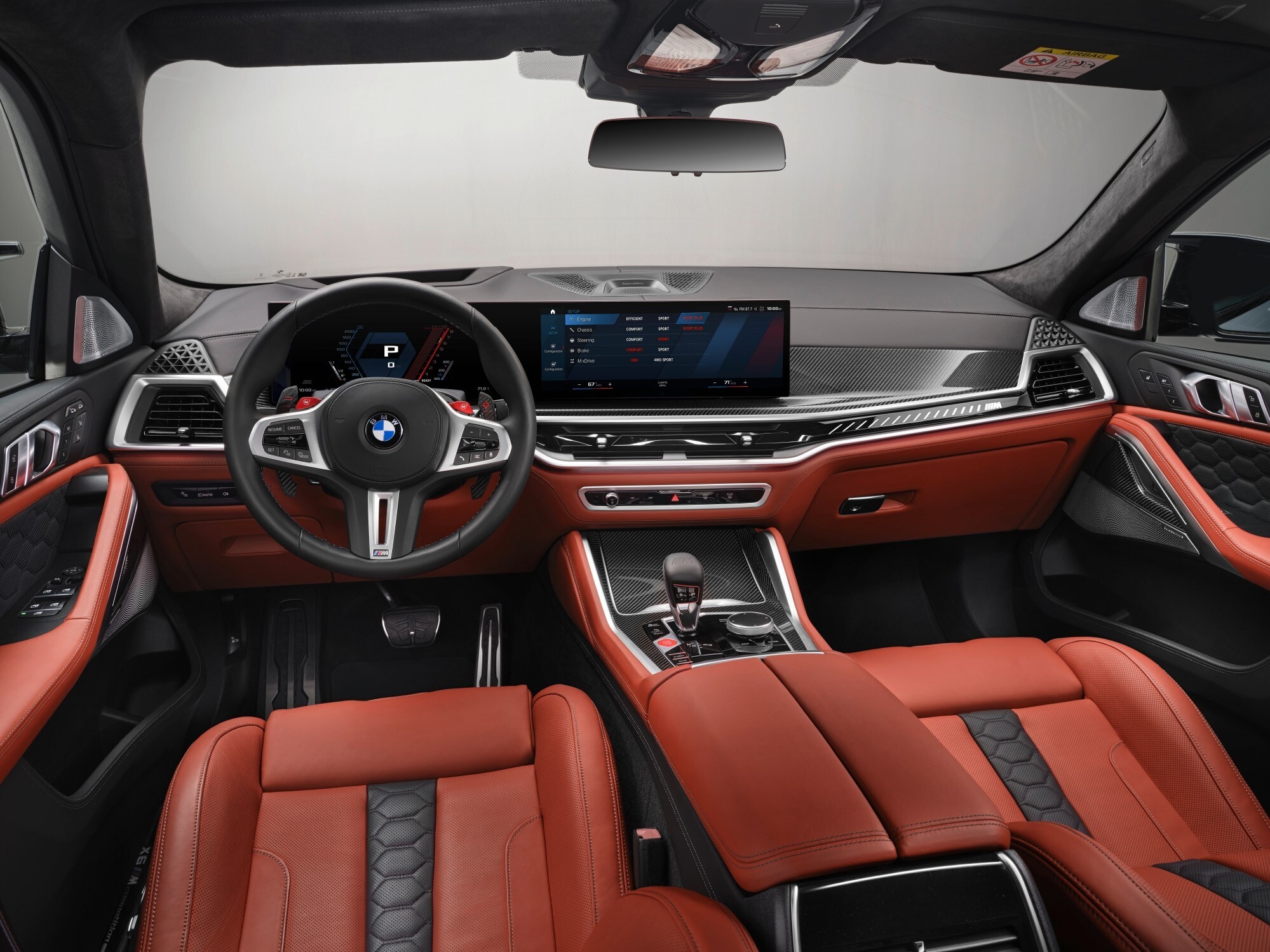 Blick aufs Armaturenbrett eines BMW mit Curved Display und Innenraum in Rot und Schwar