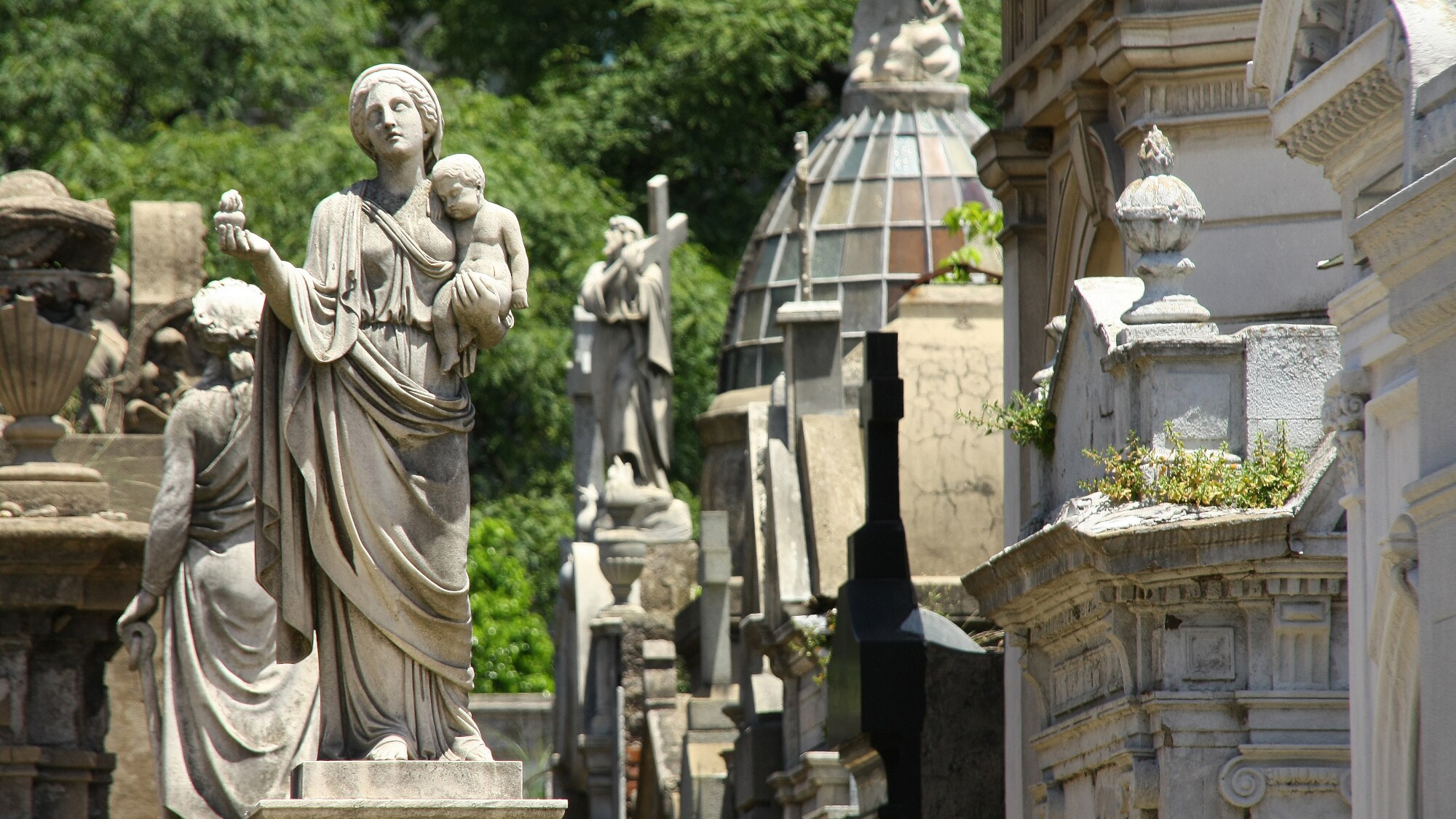 Verzierte Mausoleen mit Steinstatuen auf einem Friedhof