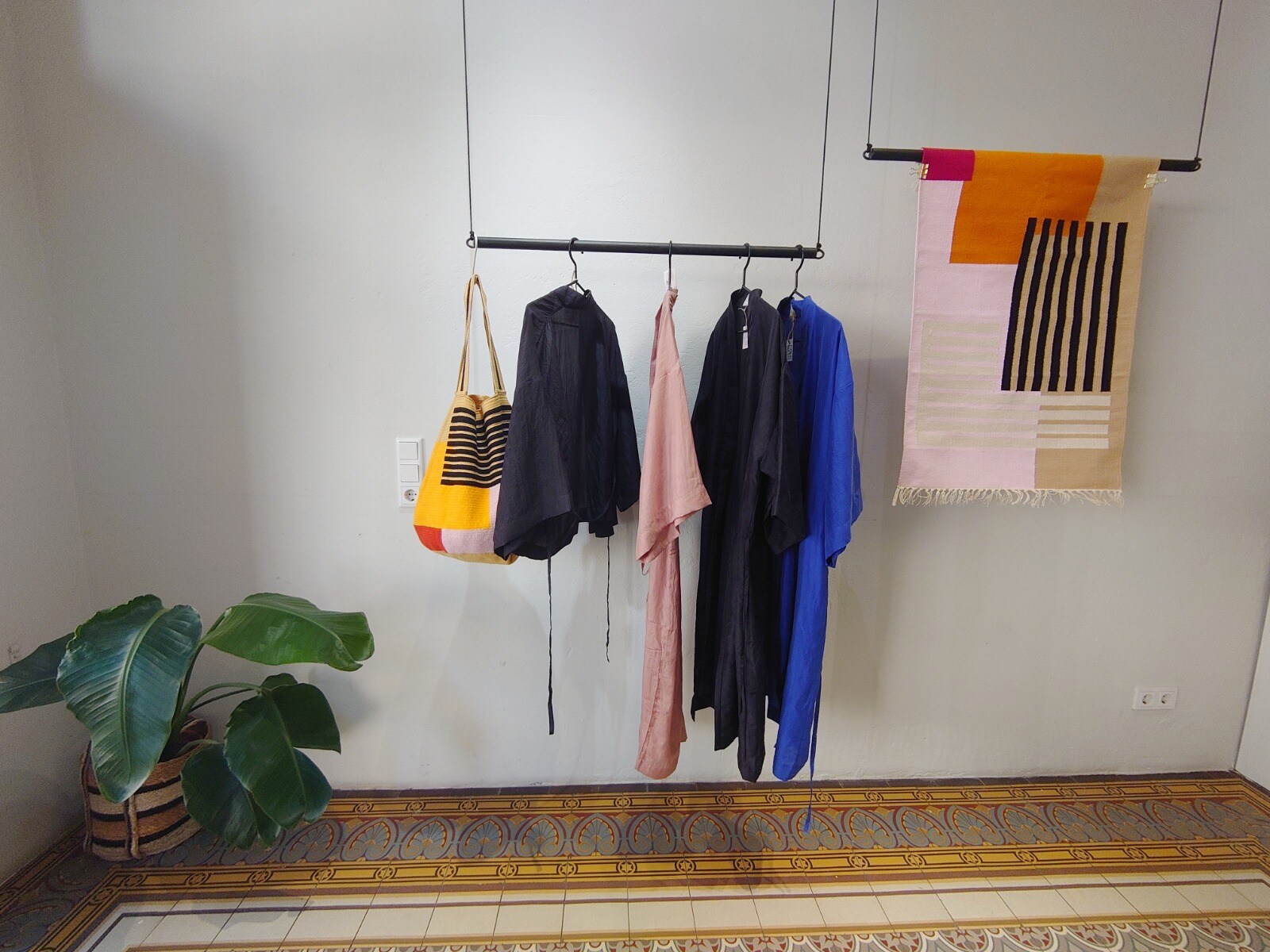 Zwei Kleiderstangen, auf denen Textilien des Labels FOLKDAYS präsentiert werden.