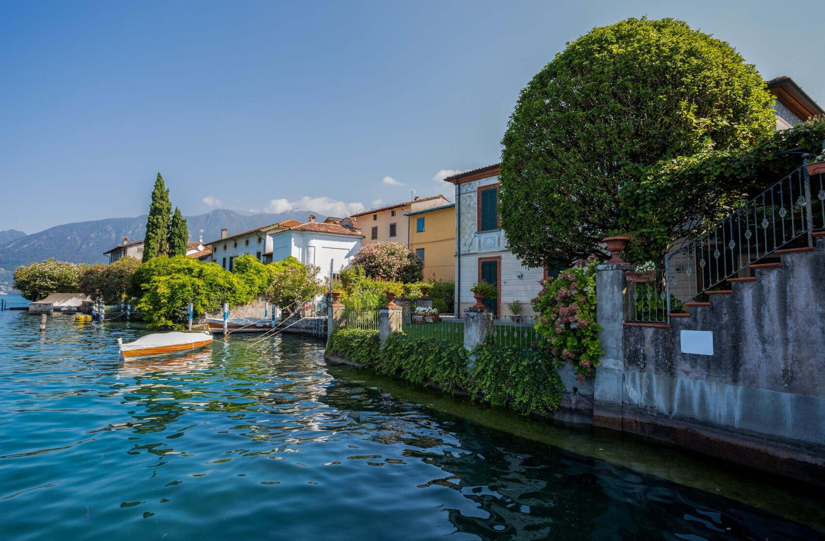 Kleiner Ort am Wasser mit mediterraner Architektur und Bootsanlegern Kleiner Ort am Wasser mit mediterraner Architektur und Bootsanlegern