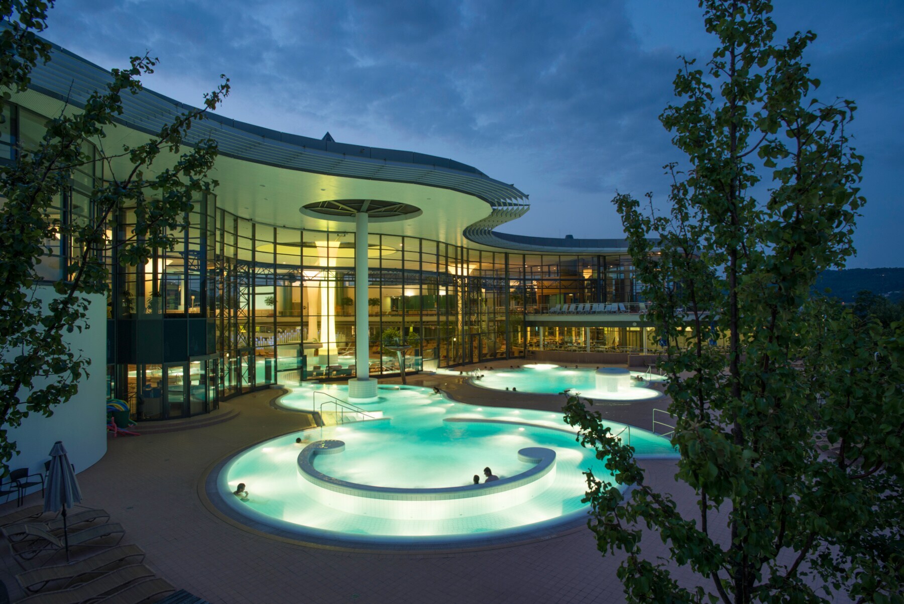 Beleuchtete Außenbecken einer Therme am Abend Beleuchtete Außenbecken einer Therme am Abend