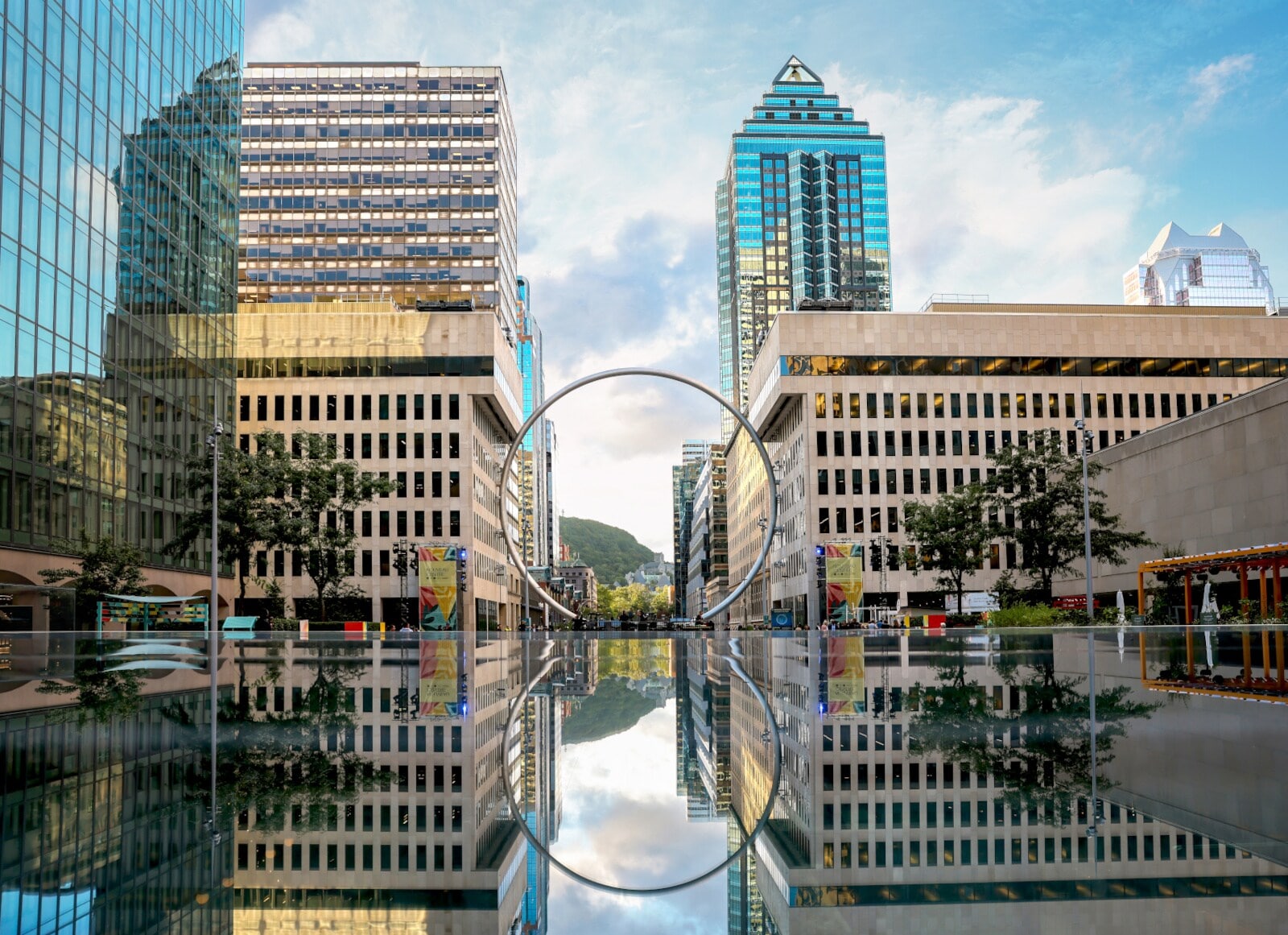 Hochhäuser vor einer Wasserfläche, in der Mitte ein großer Ring Hochhäuser vor einer Wasserfläche, in der Mitte ein großer Ring