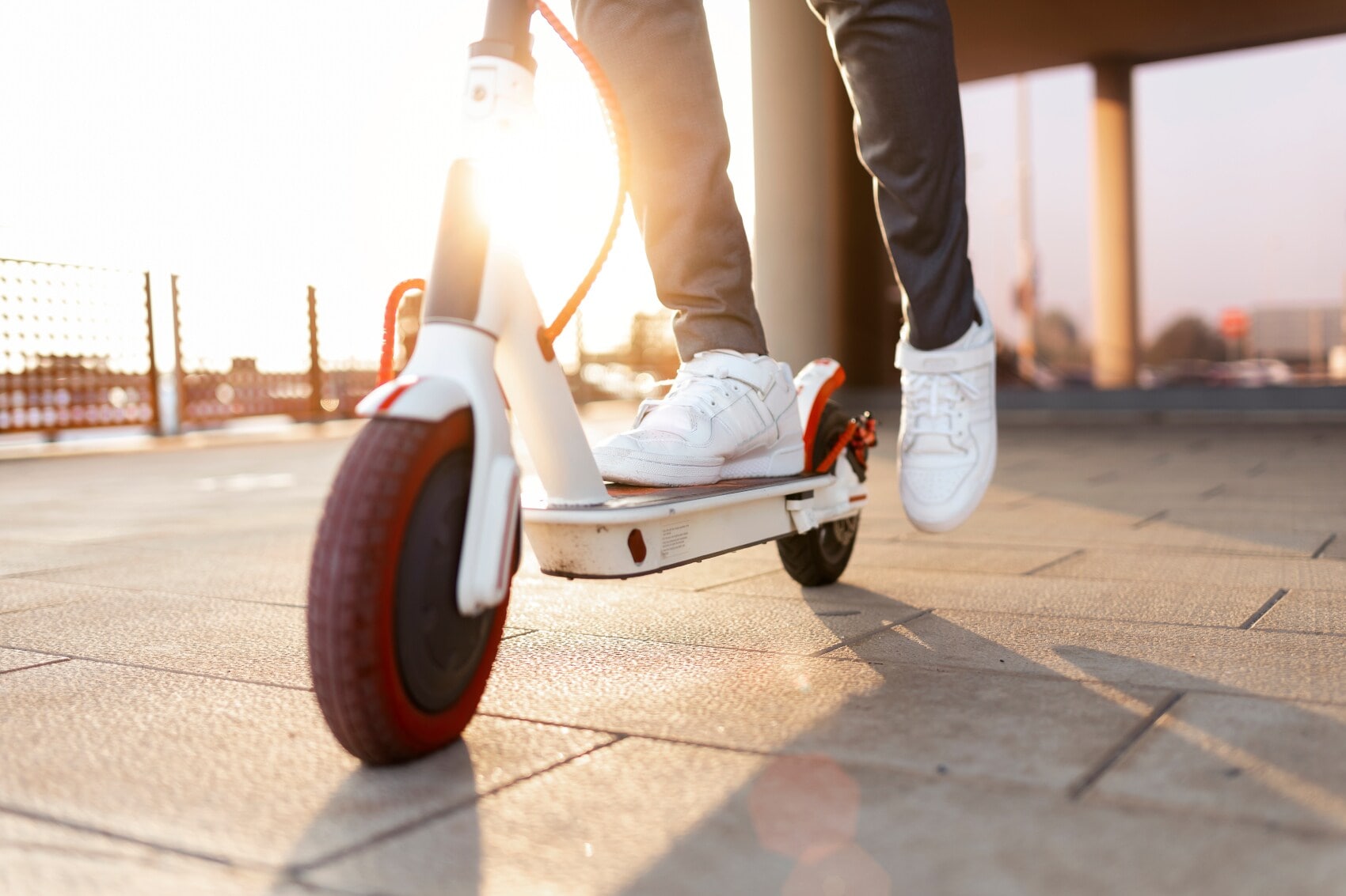 Nachaufnahme eines Rollers, auf dem ein Mann mit weißen Turnschuhen steht, Symbolbild Nachaufnahme eines Rollers, auf dem ein Mann mit weißen Turnschuhen steht, Symbolbild