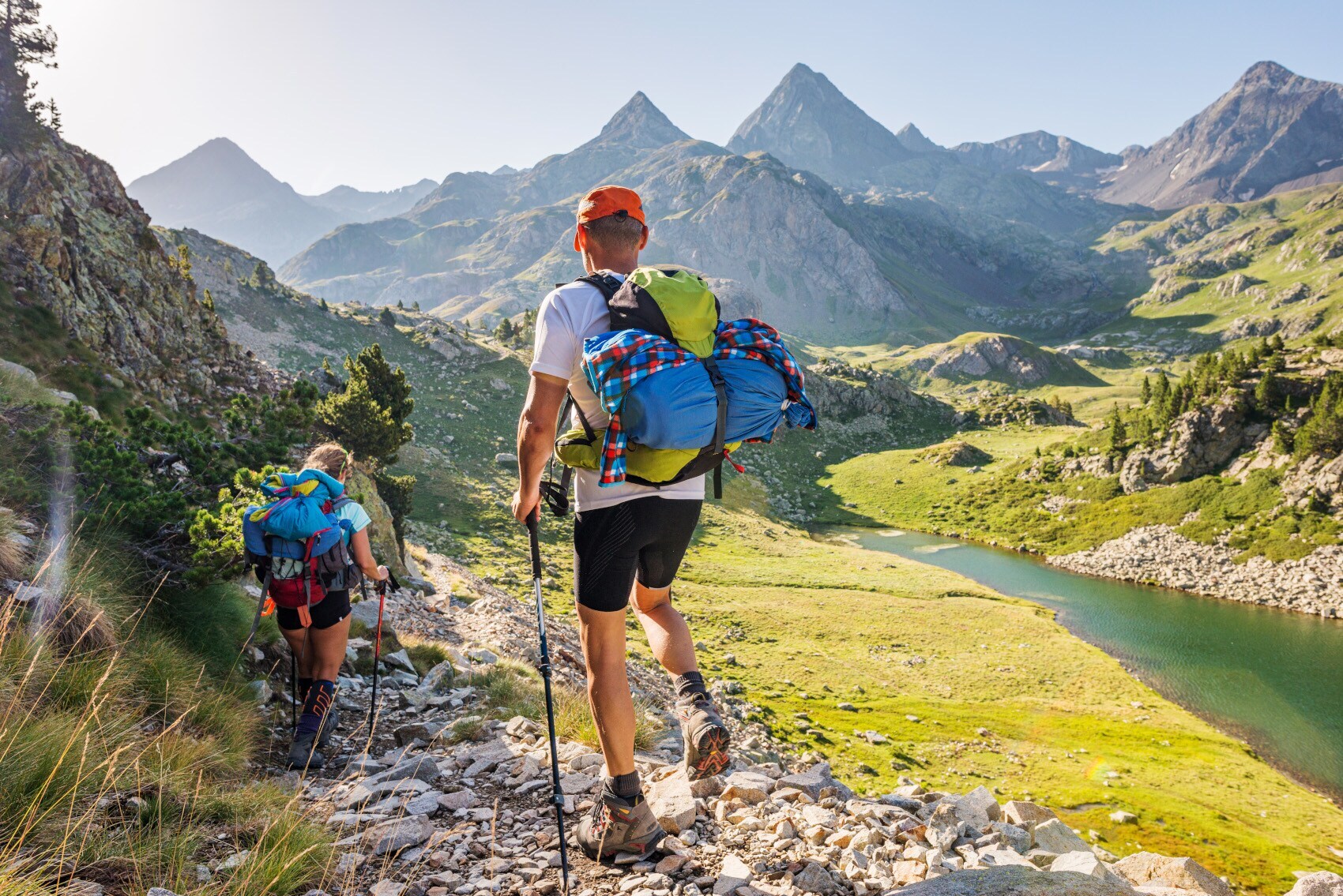 Rückansicht von zwei Wandernden mit Rucksäcken vor Bergpanorama in den Pyrenäen