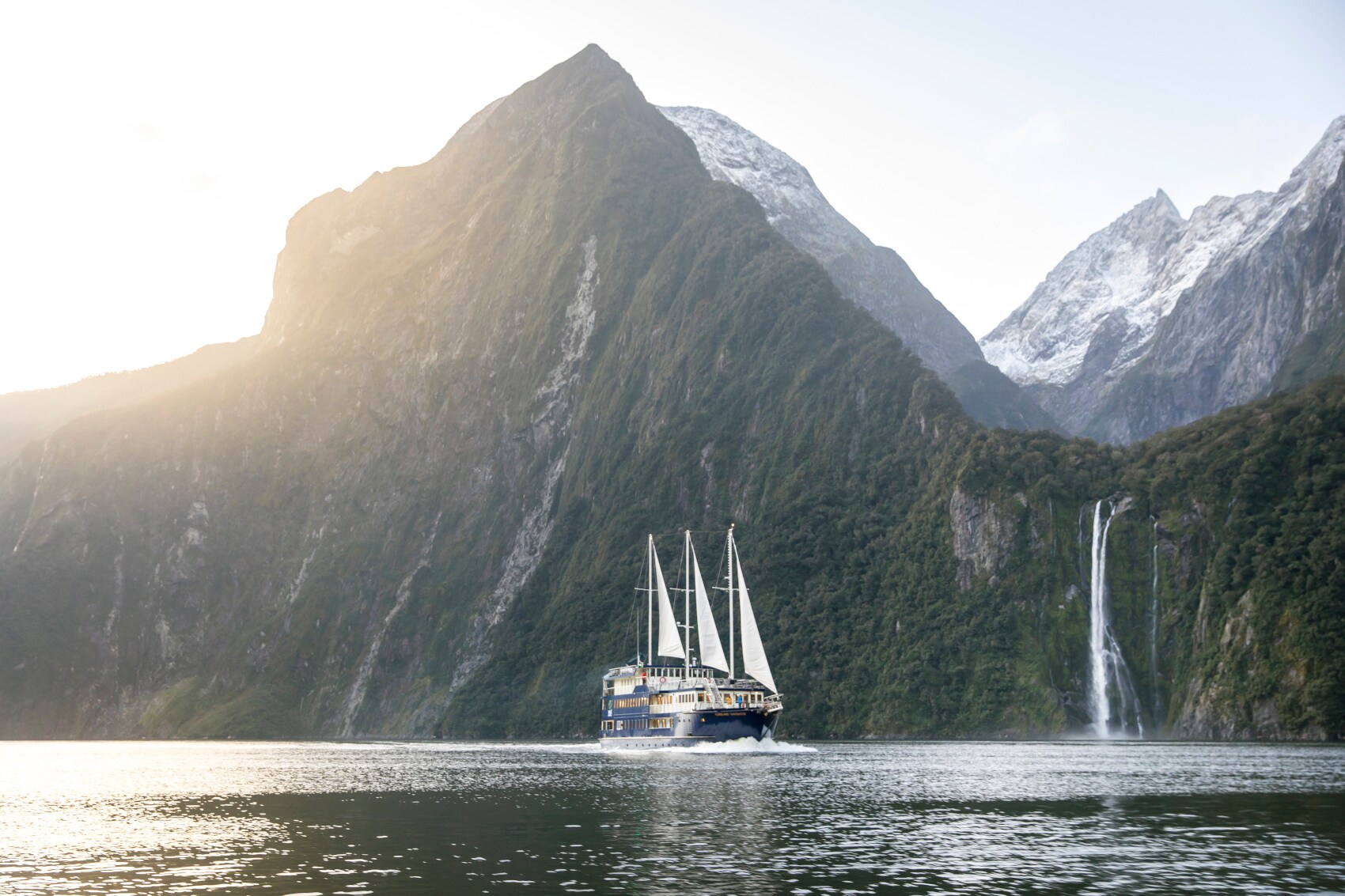 Ein Segelboot vor den Klippen von Milford Sounds