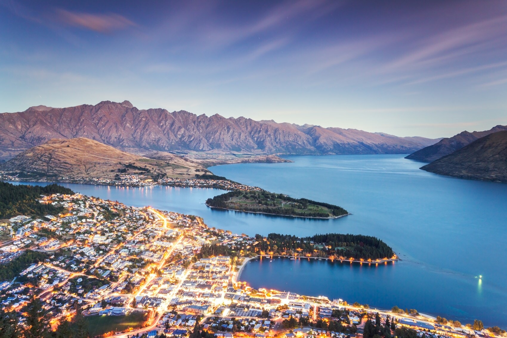 Queenstown in der Abenddämmerung mit vielen erleuchteten Straßen Queenstown in der Abenddämmerung mit vielen erleuchteten Straßen