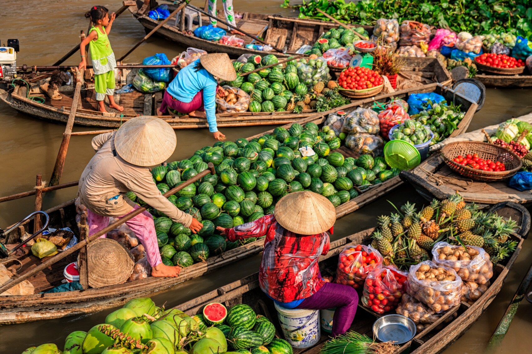 Vietnamese women Menschen fahren Boote, die mit Früchten beladen sind Menschen fahren Boote, die mit Früchten beladen sind