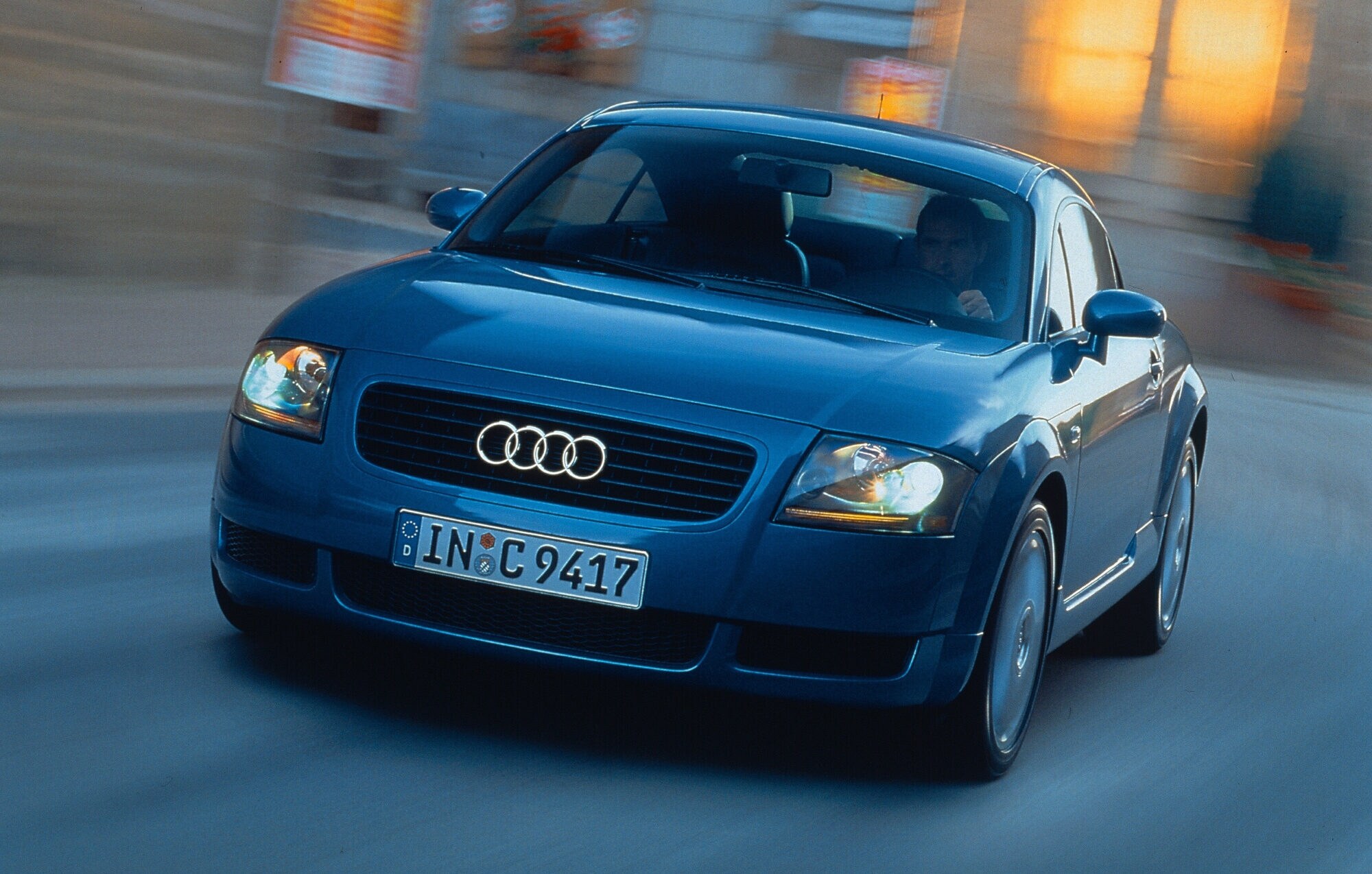 Frontalaufnahme eines fahrenden, dunkelblauen Audi TT Coupé Frontalaufnahme eines fahrenden, dunkelblauen Audi TT Coupé