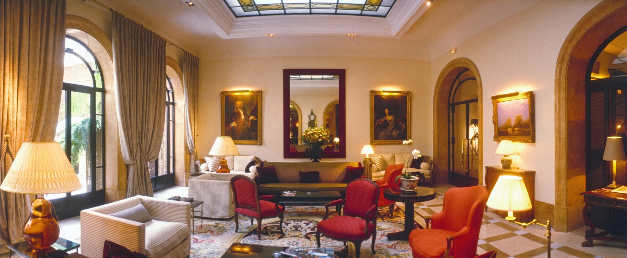 Stilvoll eingerichtetes Wohnzimmer mit luxuriöser Einrichtung, Parkettboden, bodentiefen Fenstern und einem Flügel.