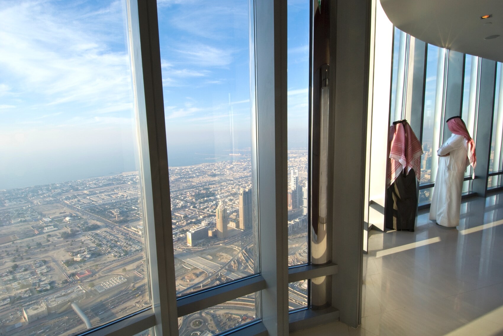 Zwei Männer stehen am Fenster und blicken über Dubai Zwei Männer stehen am Fenster und blicken über Dubai