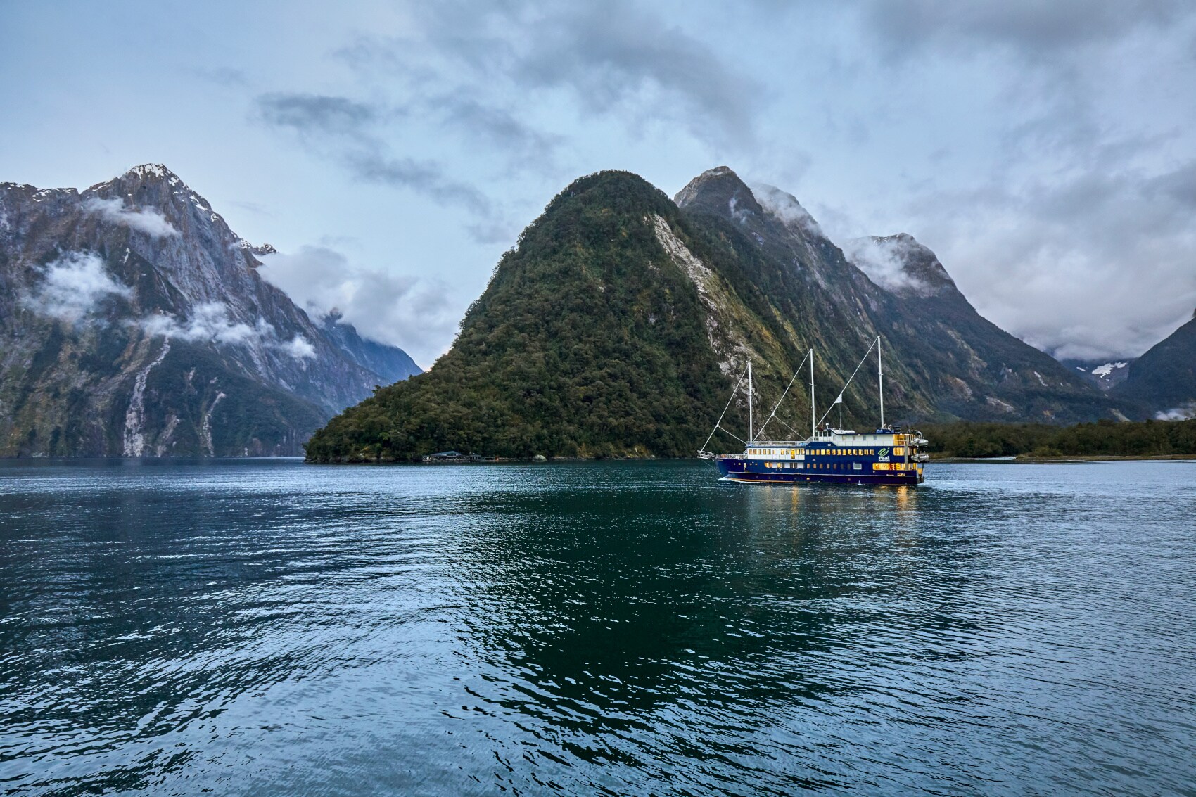 Ein Schiff vor einem Bergmassiv in Neuseeland