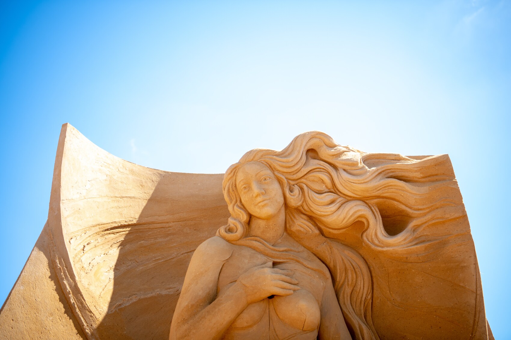 Große Sandskulptur, die eine Frau mit wallendem Haar zeigt Große Sandskulptur, die eine Frau mit wallendem Haar zeigt