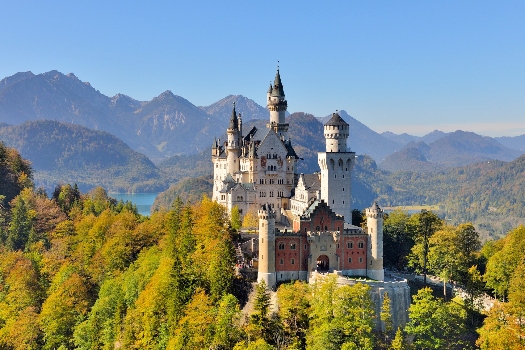 Schloss Neuschwanstein, eingebettet in bewaldete Berglandschaft Schloss Neuschwanstein, eingebettet in bewaldete Berglandschaft