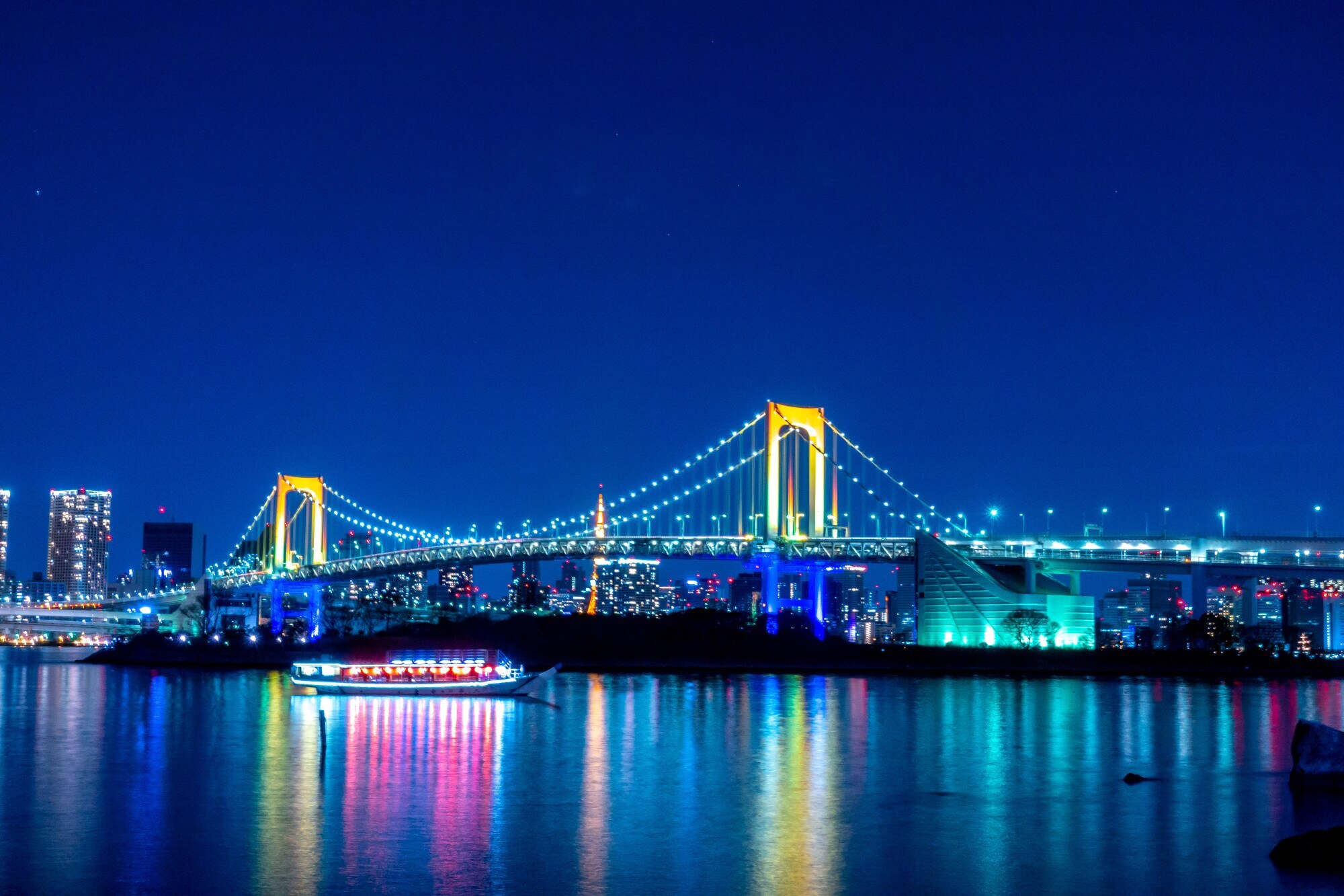Die Rainbow Bridge in Tokio strahlt in unterschiedlichen Farben