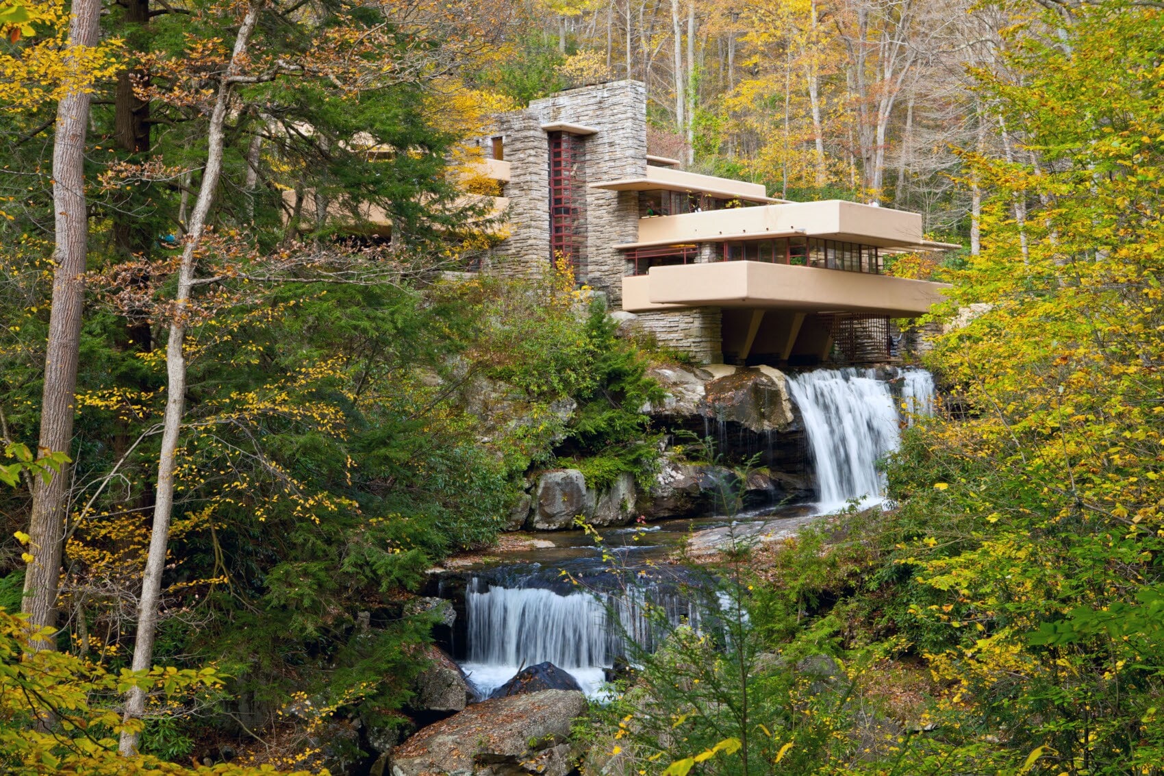 Eine mehrstöckige, über einen Wasserfall gebaute Villa in einem Waldgebiet Eine mehrstöckige, über einen Wasserfall gebaute Villa in einem Waldgebiet