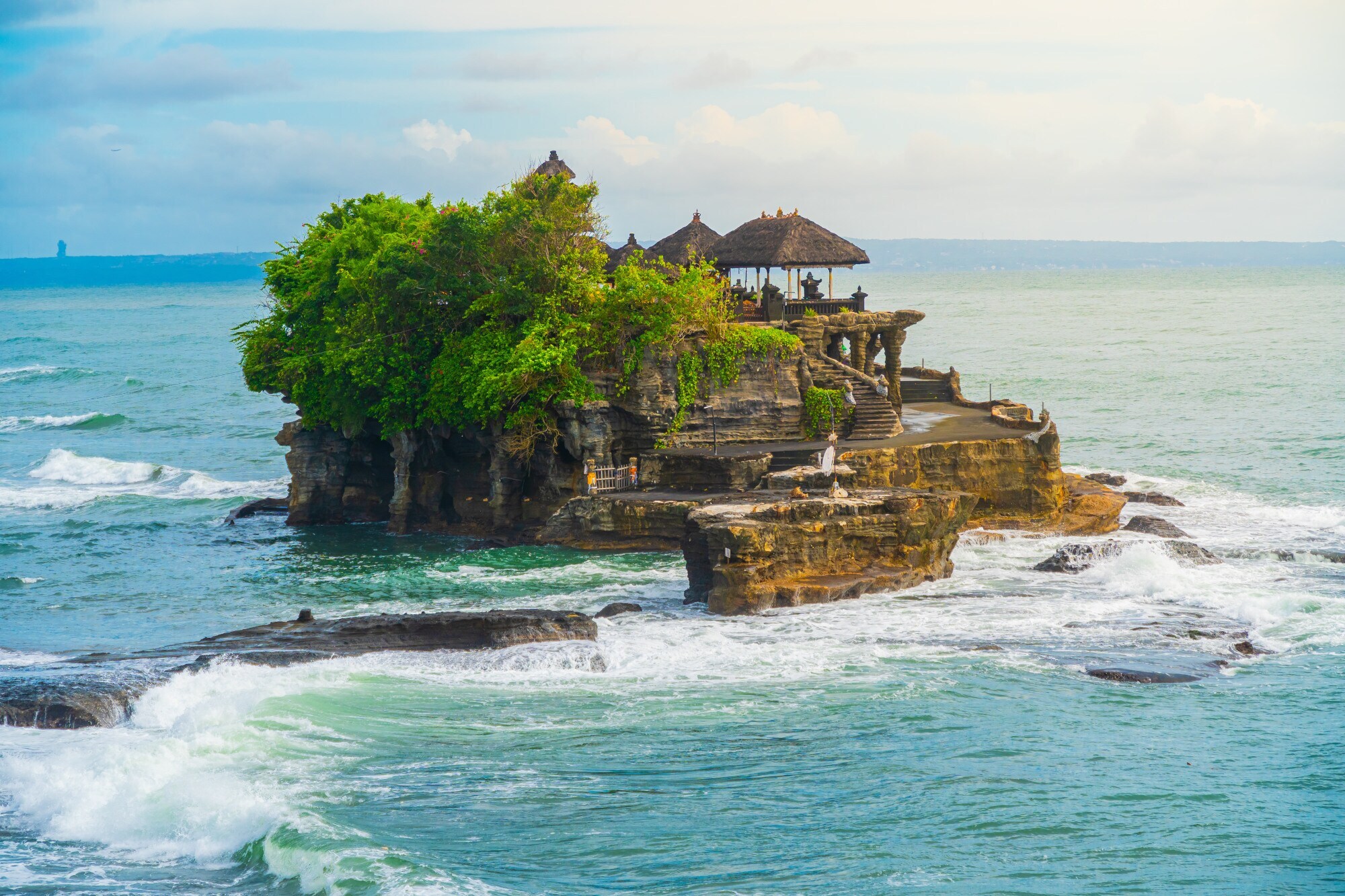 Ein Tempel und mehrere Bäume auf einem Felsen im Meer Ein Tempel und mehrere Bäume auf einem Felsen im Meer