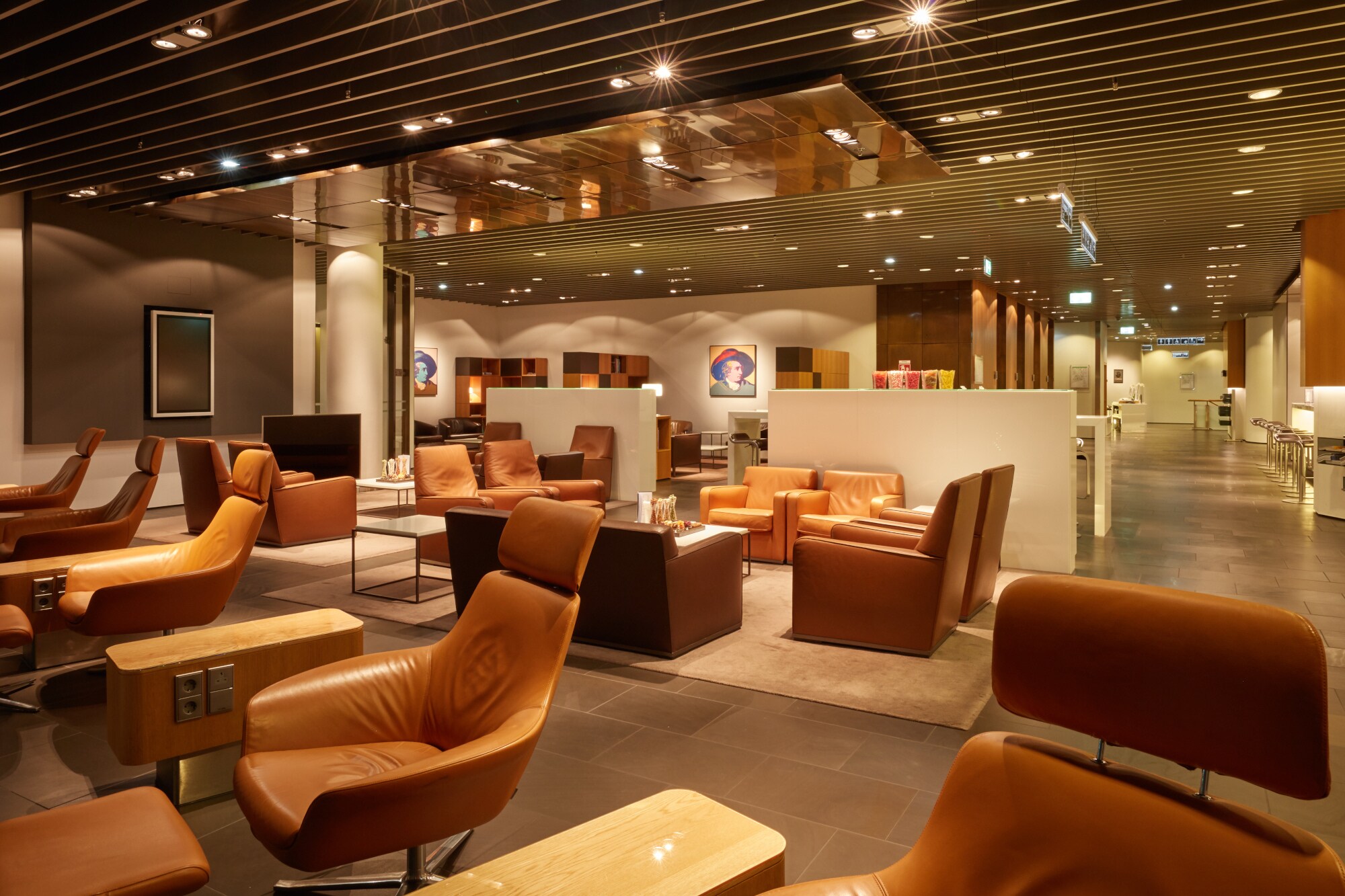 Eine weitläufige, luxuriöse Flughafen-Lounge mit cognacfarbenen Ledersesseln Eine weitläufige, luxuriöse Flughafen-Lounge mit cognacfarbenen Ledersesseln