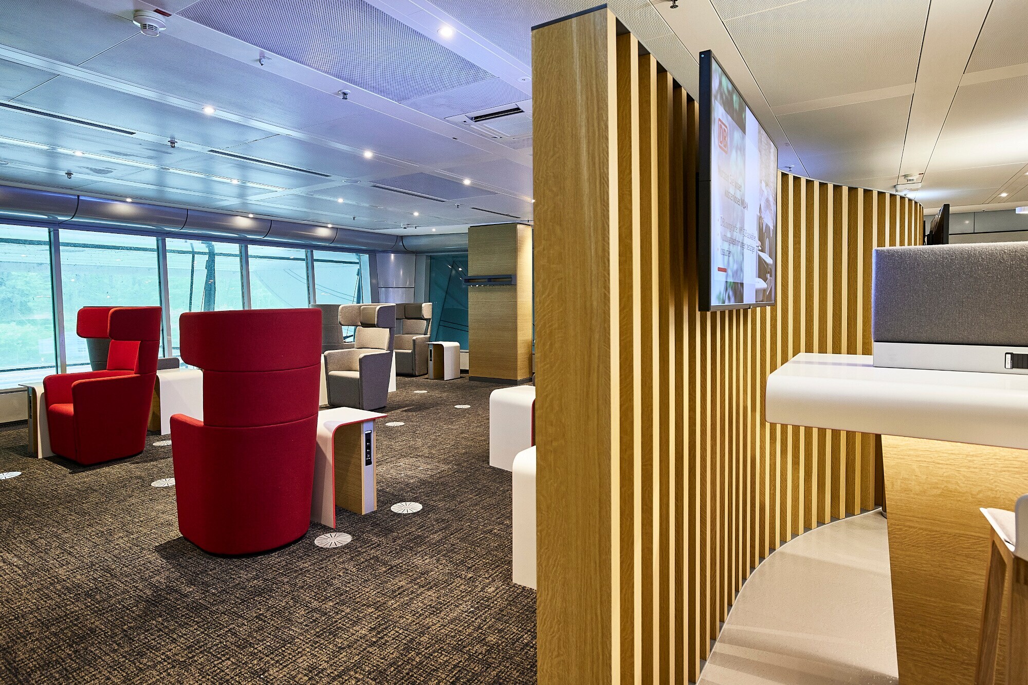 Eine Flughafen-Lounge mit Ohrensesseln und Arbeitsbereich Eine Flughafen-Lounge mit Ohrensesseln und Arbeitsbereich