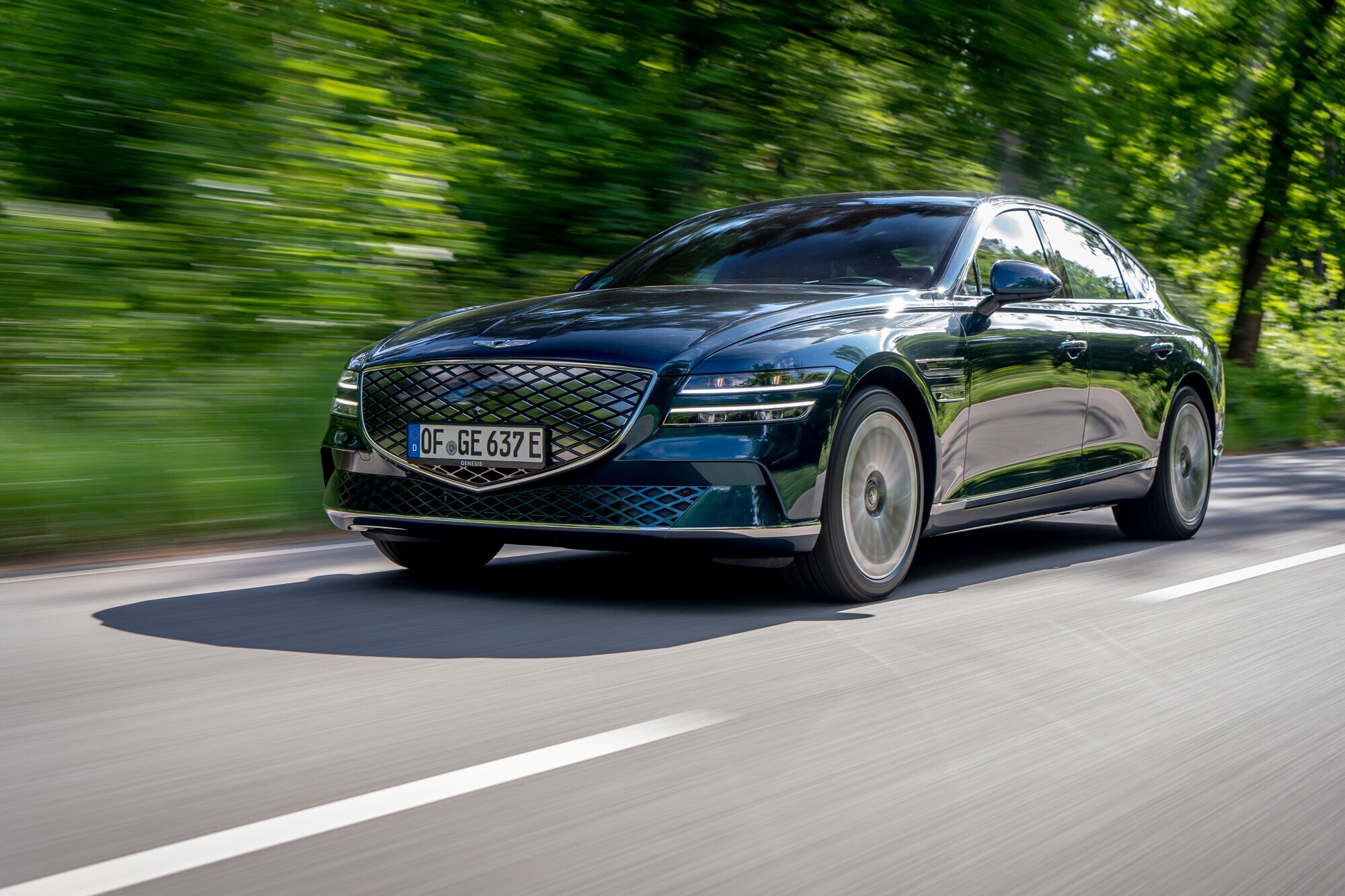 Ein dunkles Auto fährt schnell über eine Straße