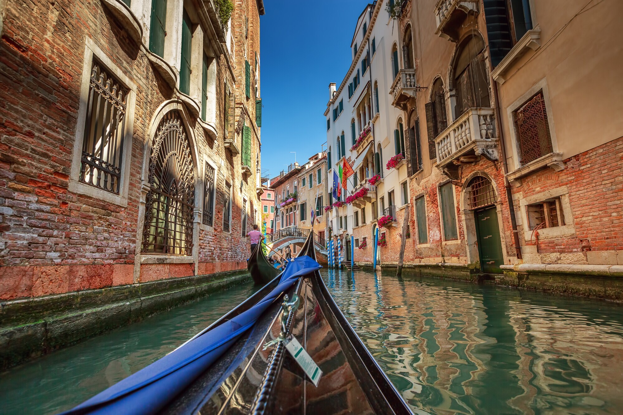 Hausfassaden an einem Wasserkanal in Venedig mit dem Bug einer Gondel im Vordergrund