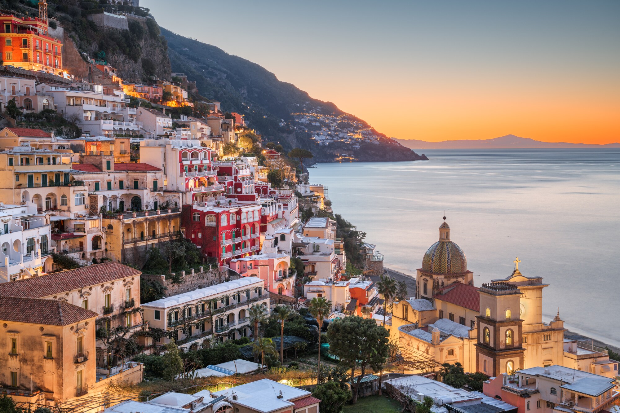 italien-regionen-amalfikueste Das Dorf Positano am Hang eines gebirgigen Küstenabschnittes bei Sonnenuntergang